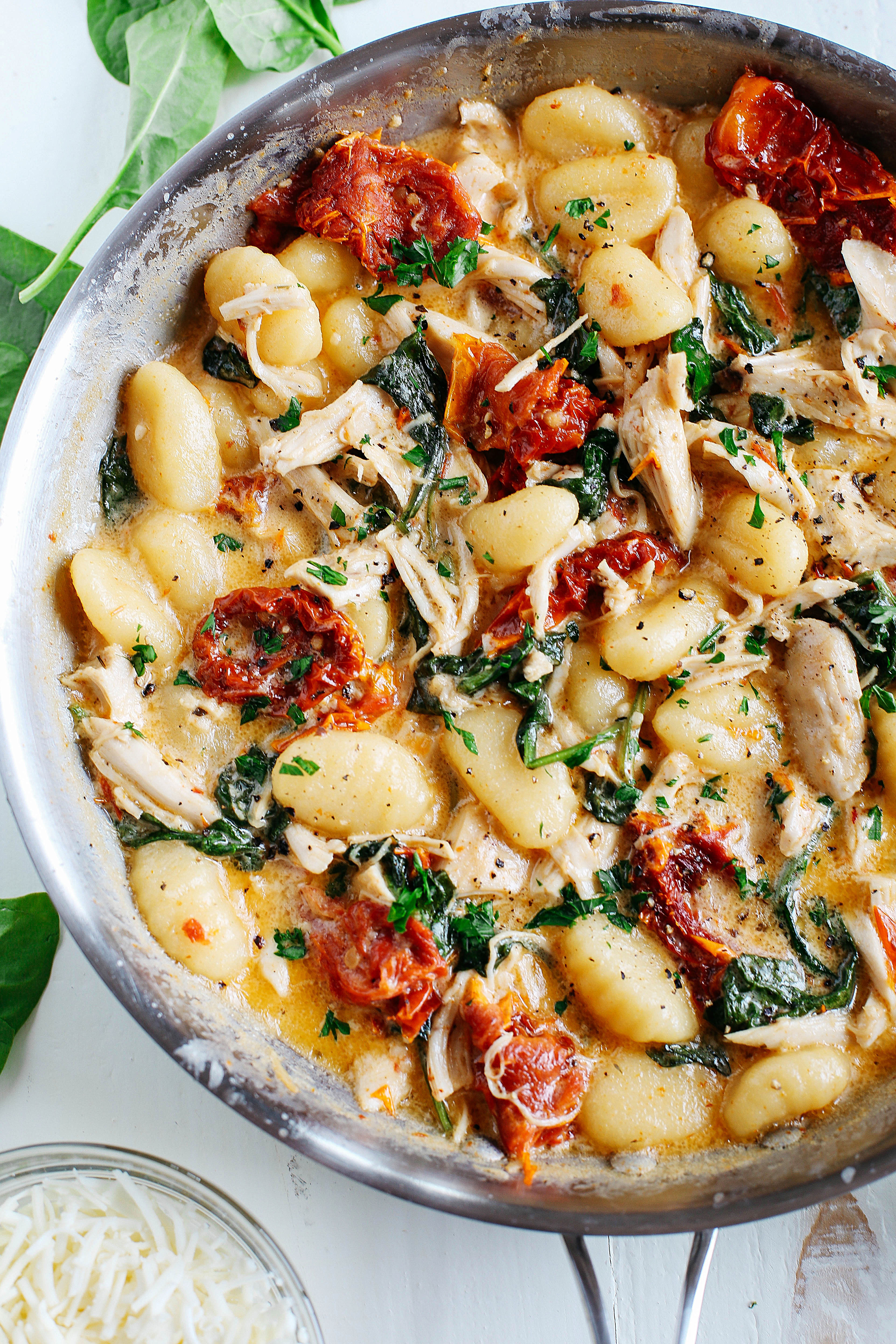 This EASY One Skillet Sun Dried Tomato Chicken and Gnocchi is the perfect weeknight dish that is tossed together with spinach, garlic and shredded asiago cheese and made in under 30 minutes! 