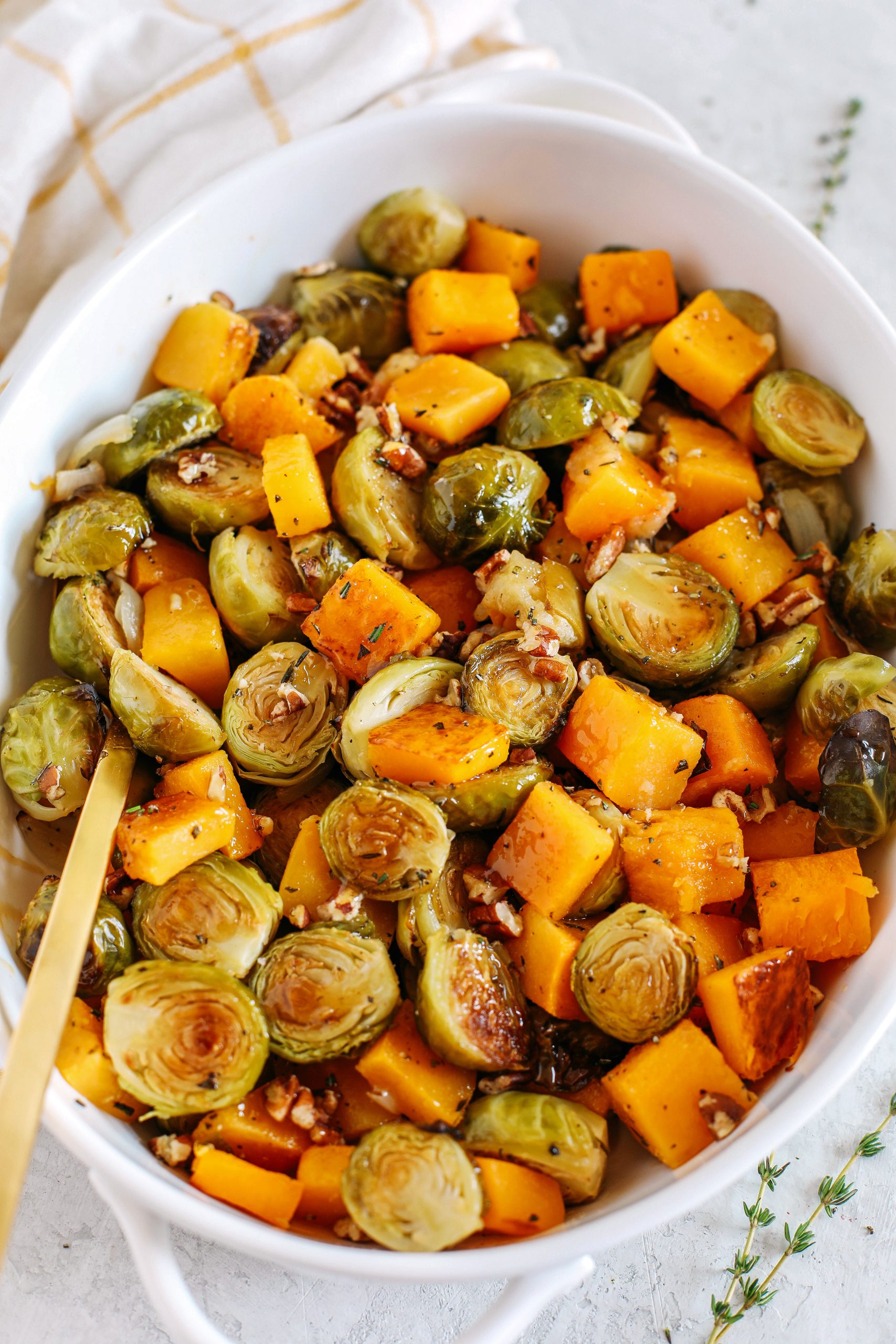Roasted butternut squash, brussels sprouts and apples all tossed together with fresh herbs, chopped pecans and drizzled with a delicious maple dijon glaze!  The perfect side dish to your holiday meal!