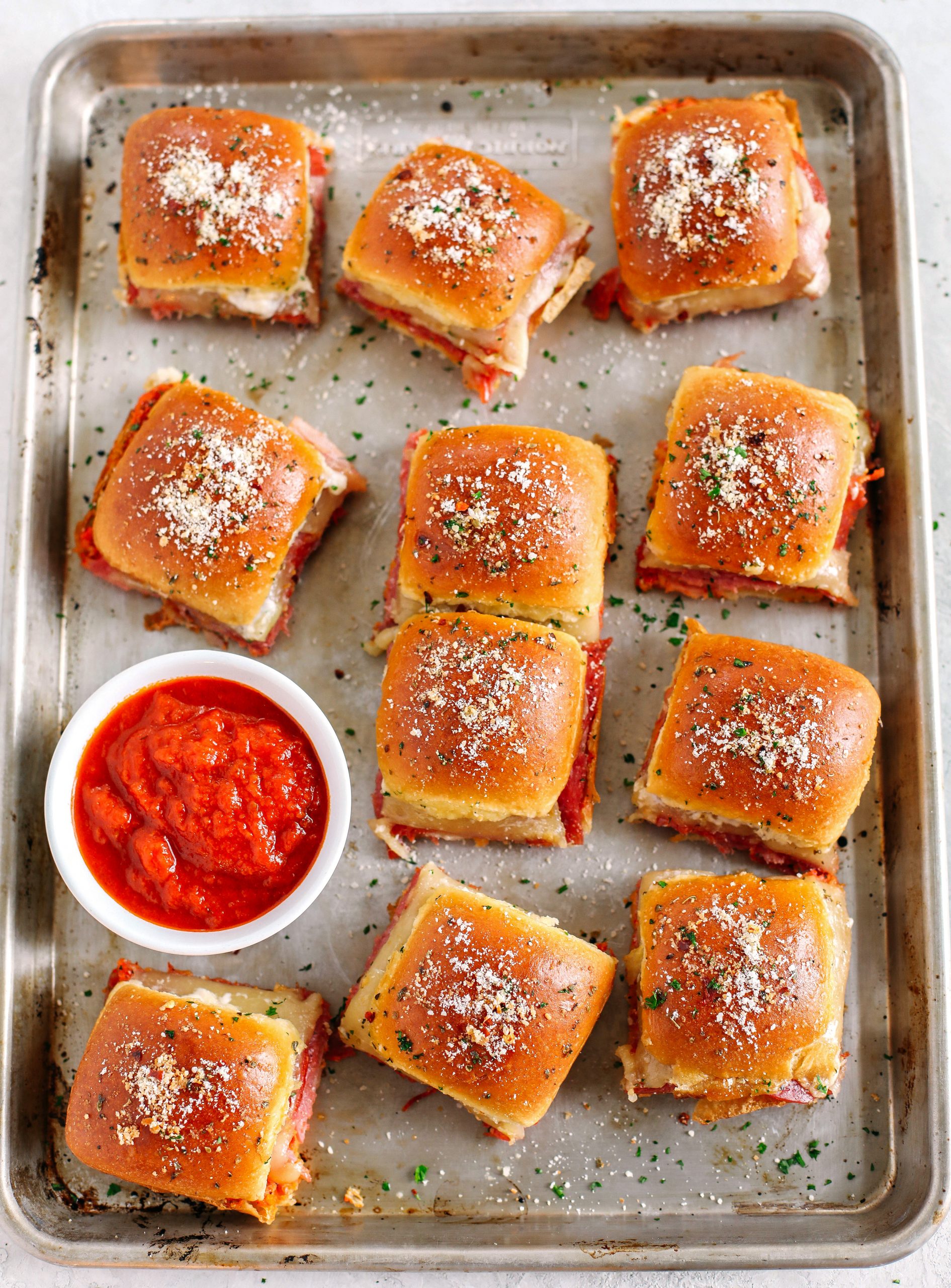Delicious Hot Italian Sliders perfect for game day that are layered with slices of ham, salami, pepperoni and provolone with a homemade roasted red pepper spread!