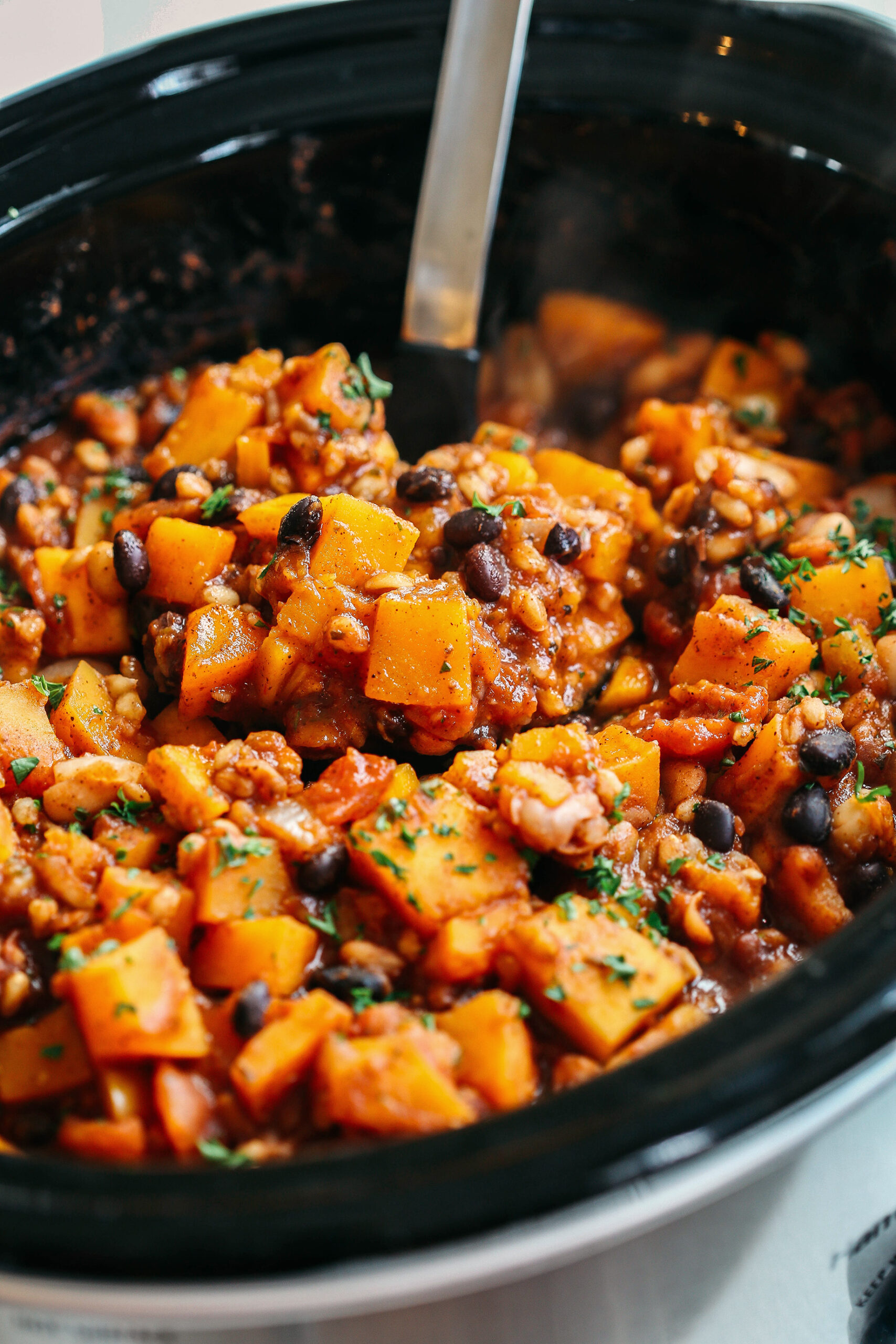 This slow-cooking pumpkin and Farro chili is filling, healthy, and loaded with seasonal vegetables, tender farro, protein-packed beans, and cozy spices, all simmered in a delicious broth for the perfect fall meal!