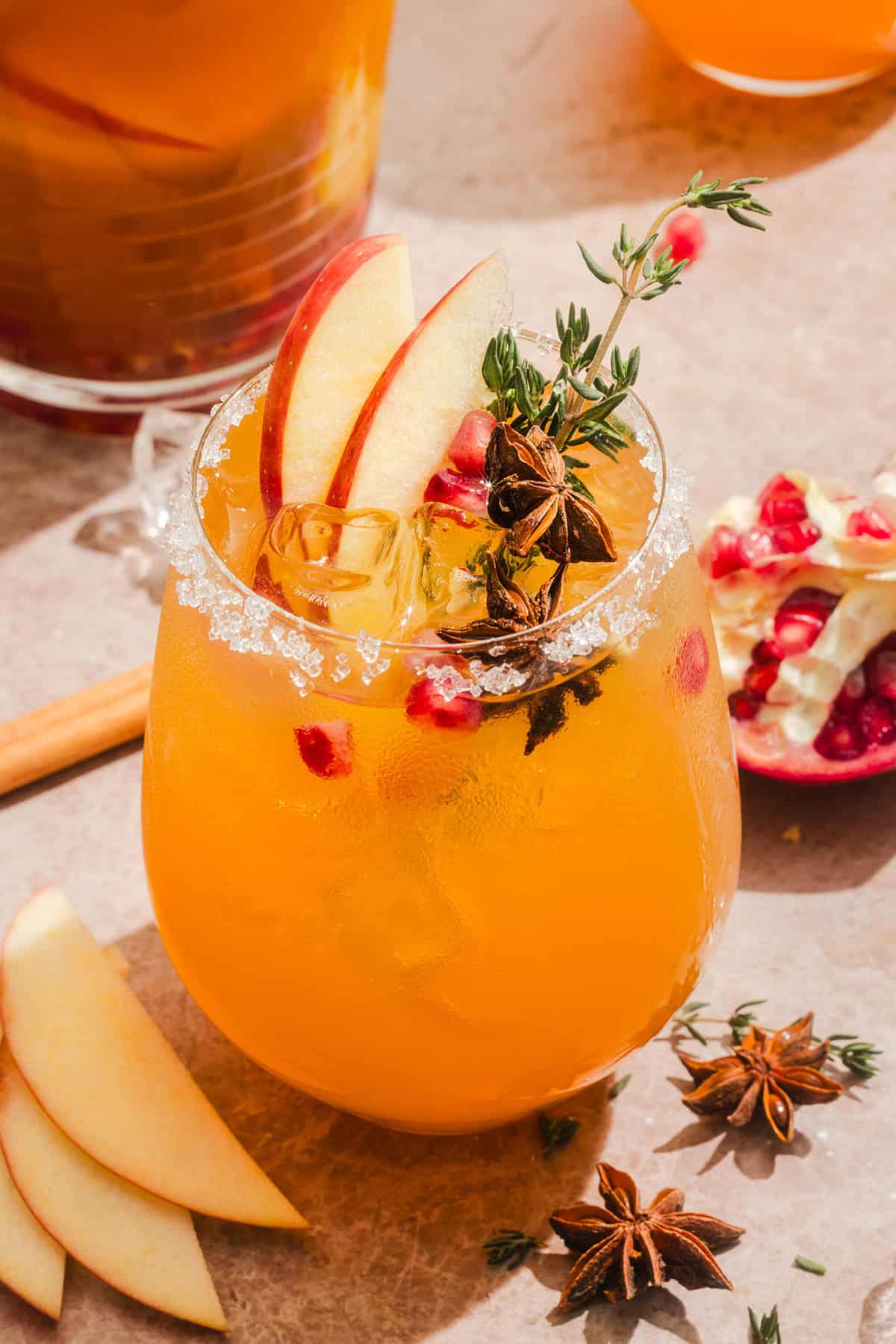 Glass of fall sangria with apple cider, orange slices, fresh apples and cinnamon