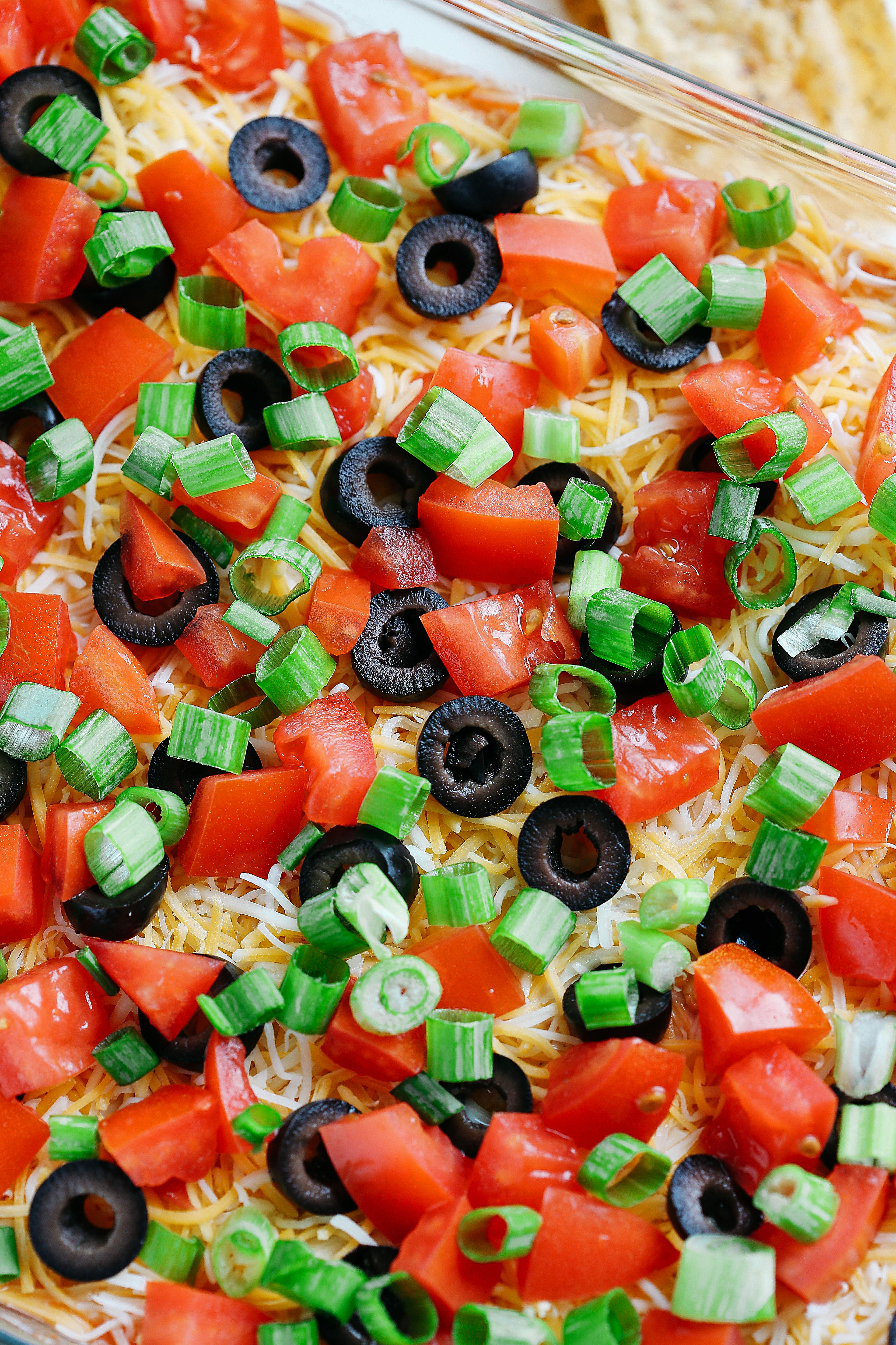 This Healthier 7 Layer Spicy Taco Dip is a lighter take on your favorite party appetizer perfect for any gathering or event that you can enjoy guilt-free!