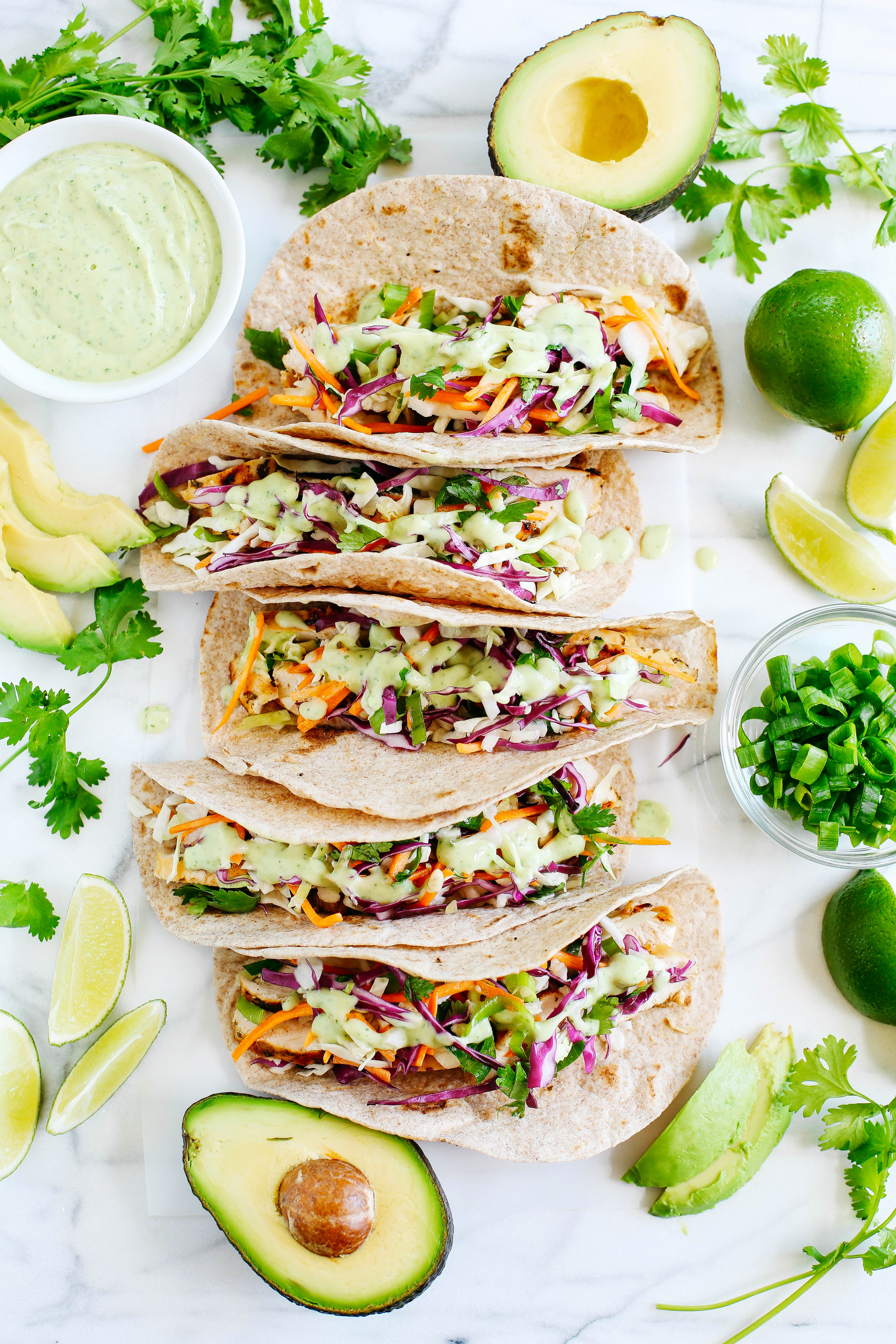 These Cilantro Lime Chicken Tacos with tangy coleslaw and avocado crema are simple, fresh and delicious making this the perfect EASY summer recipe!