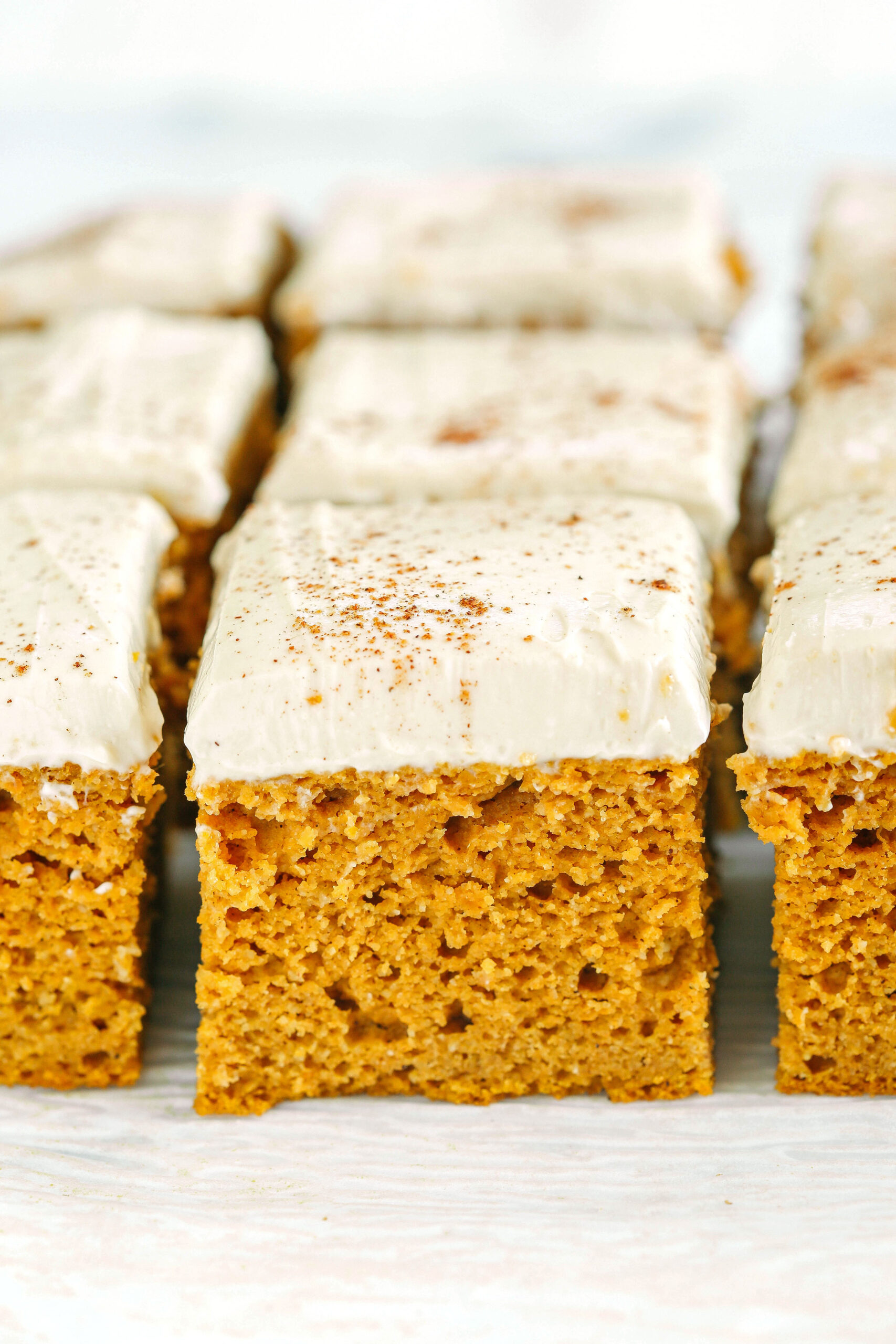 These Healthier Pumpkin Bars are moist, taste just like cake, and are made without any butter, oil or refined sugar!  Topped with a delicious maple cream cheese frosting and loaded with so much pumpkin flavor!