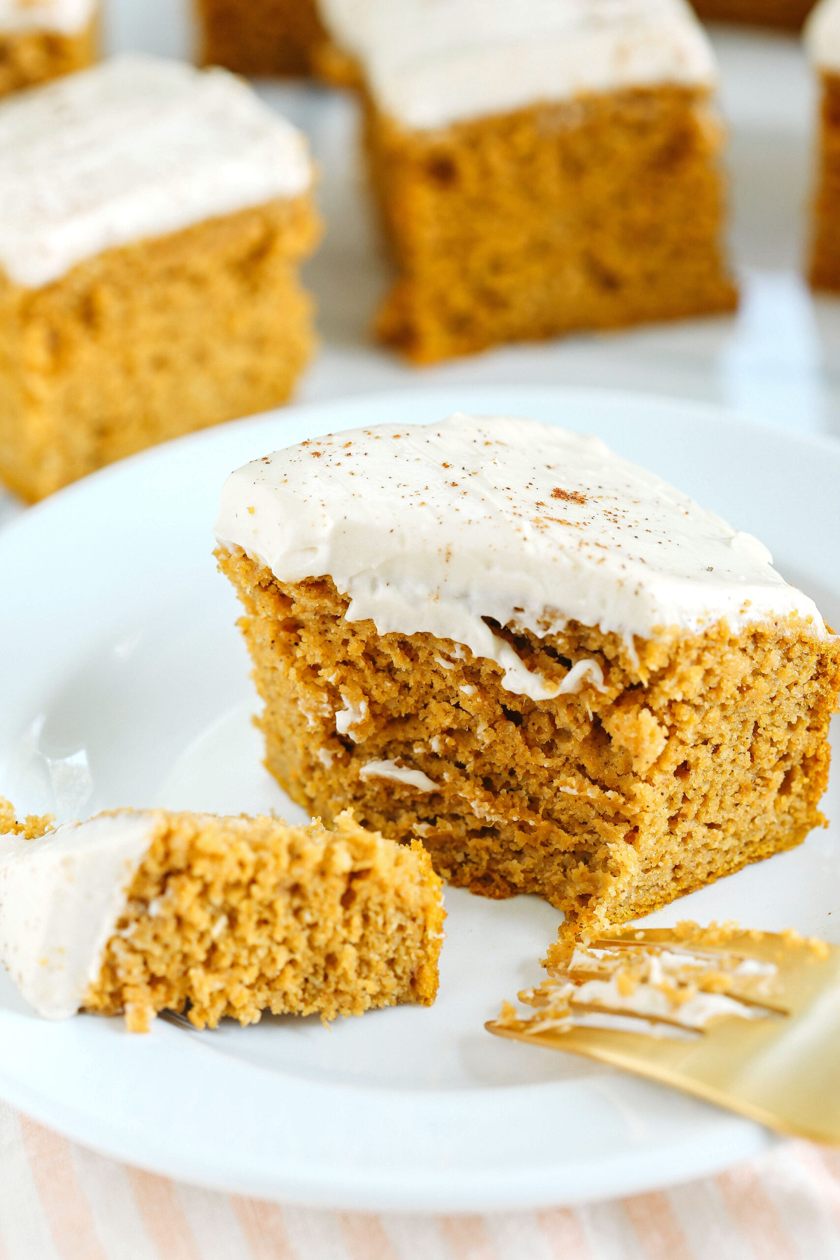 These Healthier Pumpkin Bars are moist, taste just like cake, and are made without any butter, oil or refined sugar!  Topped with a delicious maple cream cheese frosting and loaded with so much pumpkin flavor!