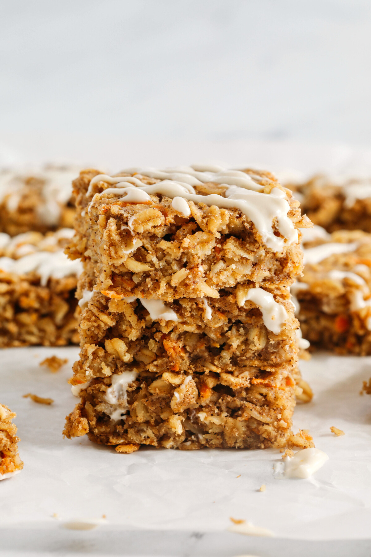 These EASY Carrot Cake Oatmeal Breakfast Bars make a quick on-the-go breakfast, snack or healthy dessert made with zero refined sugar and drizzled with a delicious maple cream cheese frosting! 