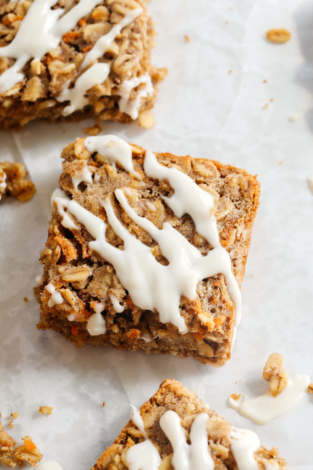 These EASY Carrot Cake Oatmeal Breakfast Bars make a quick on-the-go breakfast, snack or healthy dessert made with zero refined sugar and drizzled with a delicious maple cream cheese frosting! 