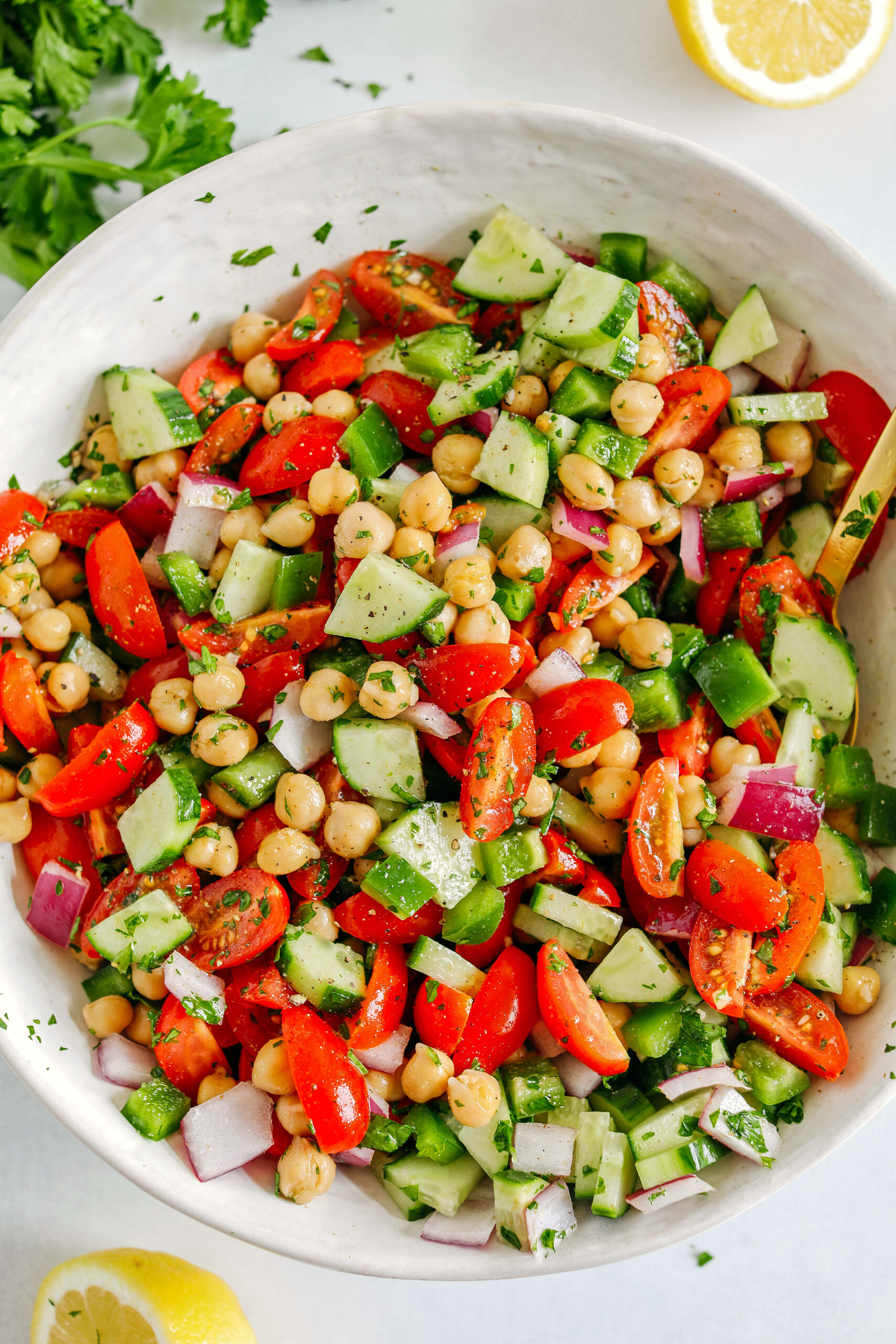 This Tomato, Cucumber and Chickpea Salad is a delicious summer staple made with fresh tomatoes, crisp cucumbers, chickpeas, red onion, and green bell pepper all tossed with a bright lemon vinaigrette!  Easy, healthy and the perfect side dish with grilled chicken, fish or steak!