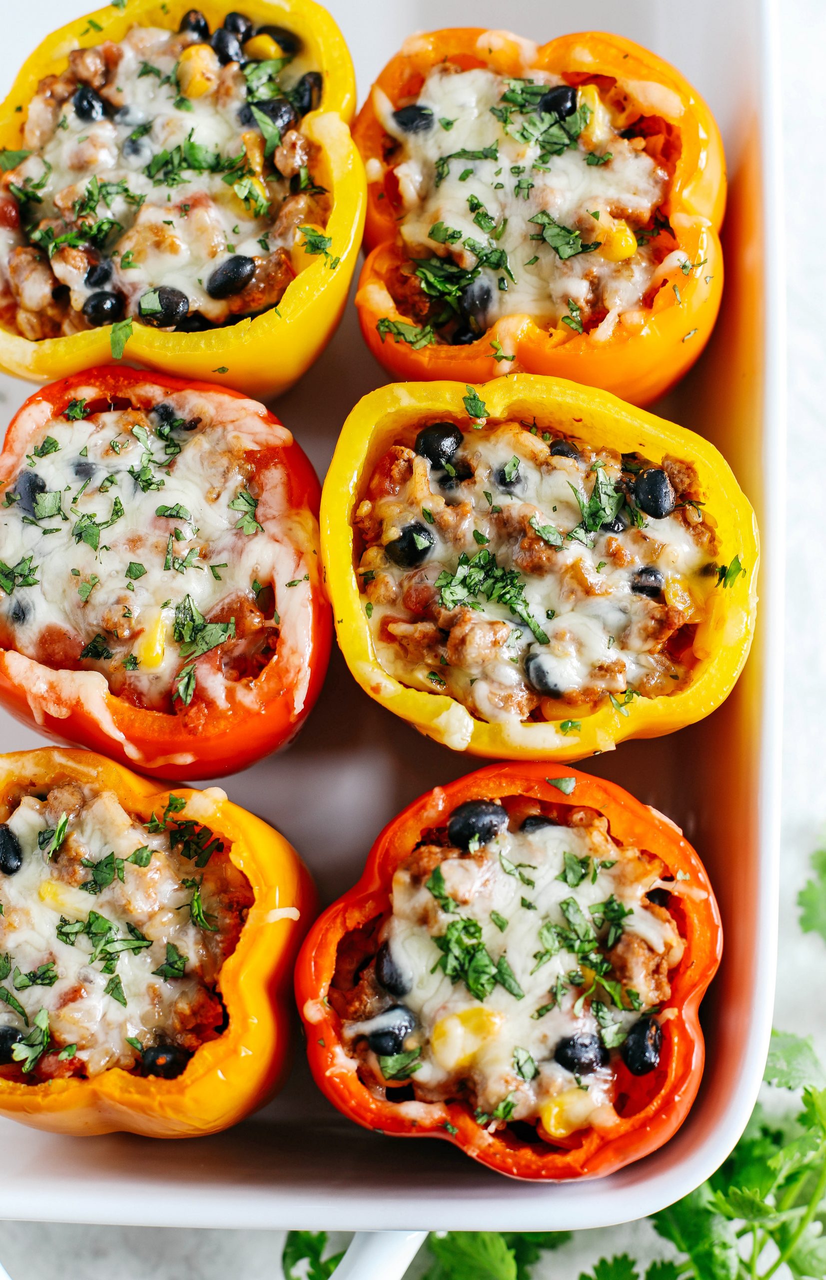 Light and healthy Mexican Stuffed Bell Peppers filled with seasoned ground turkey, brown rice, corn and black beans all topped with melted cheese!