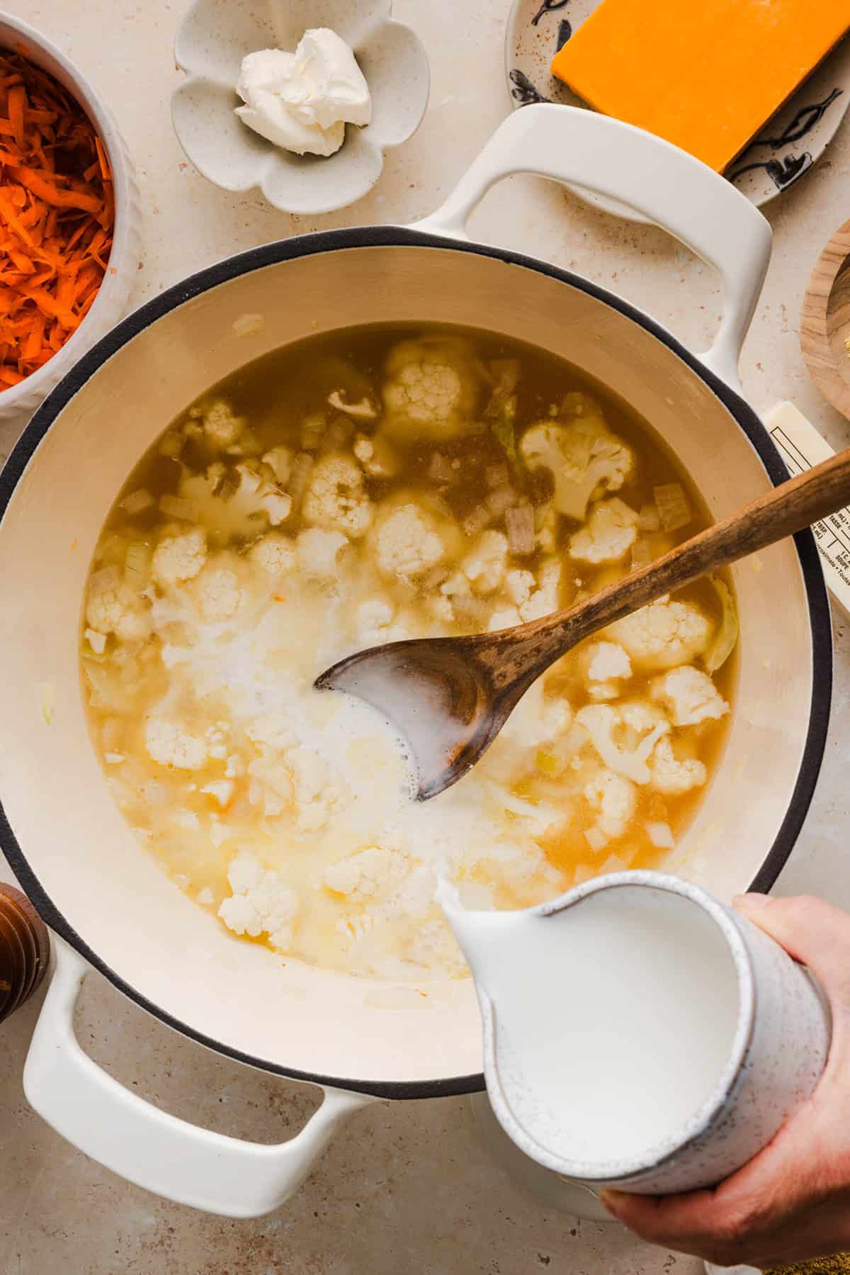 Cauliflower simmering in a large pot for broccoli cheddar soup.