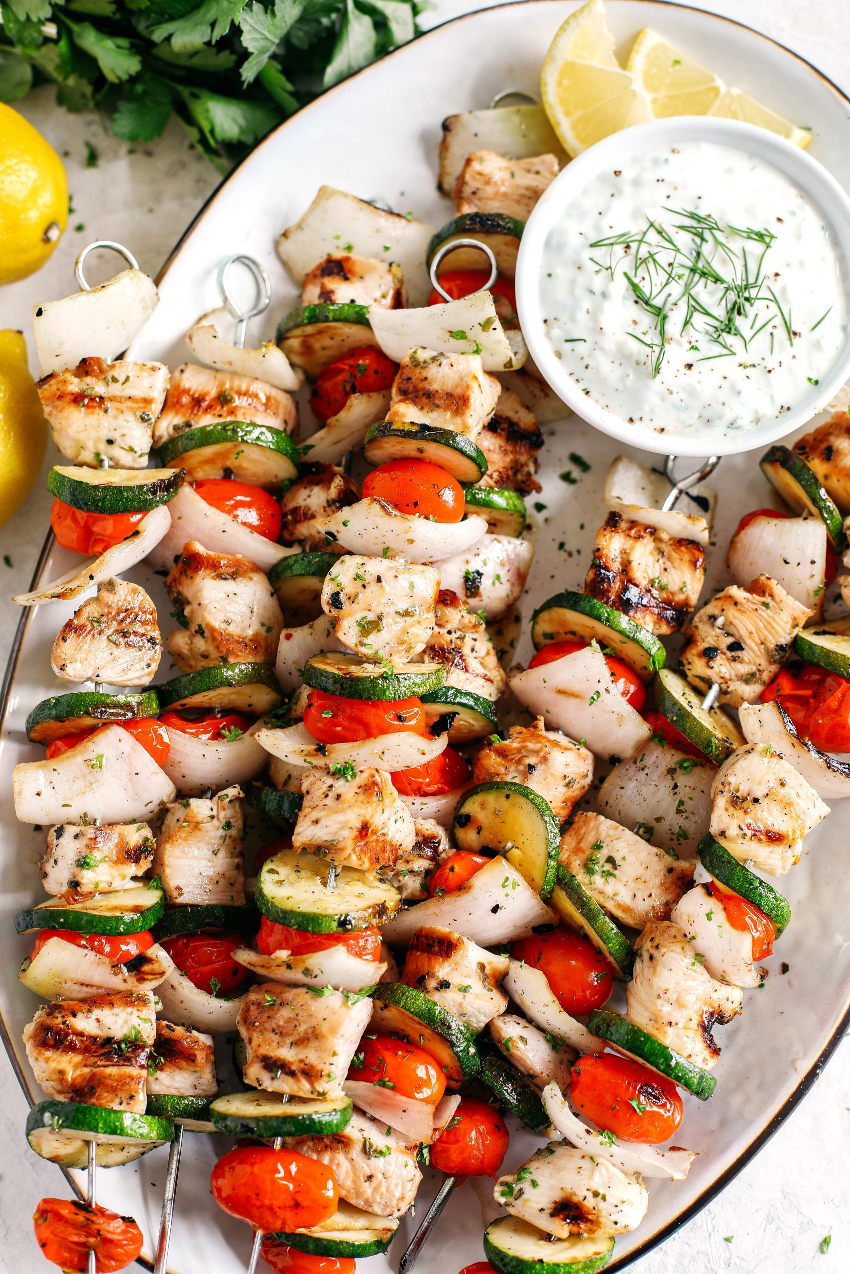 Super flavorful Greek Chicken Kabobs marinated with zesty lemon juice, garlic and fresh herbs and served with the most delicious homemade tzatziki dipping sauce!