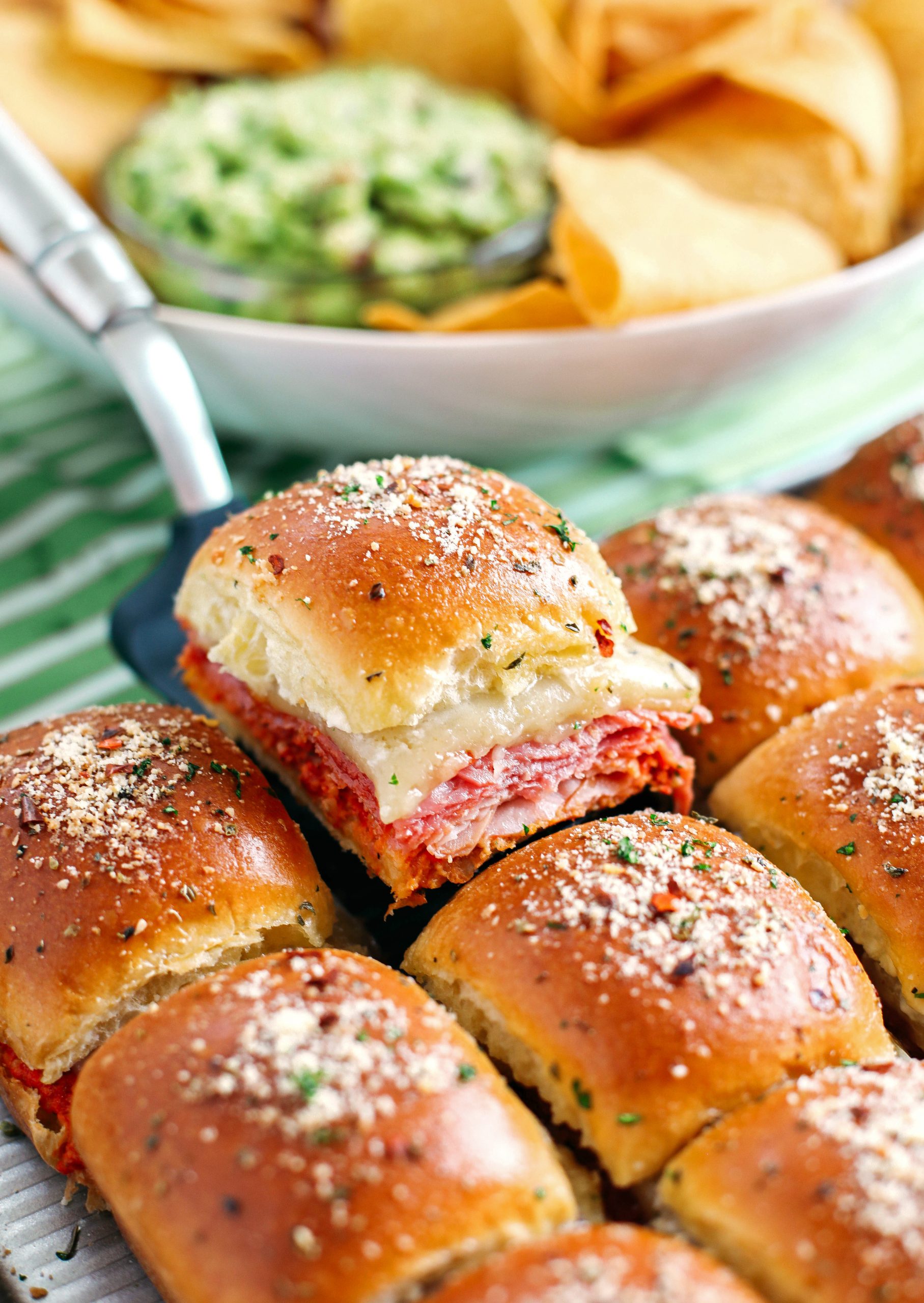 Delicious Hot Italian Sliders perfect for game day that are layered with slices of ham, salami, pepperoni and provolone with a homemade roasted red pepper spread!