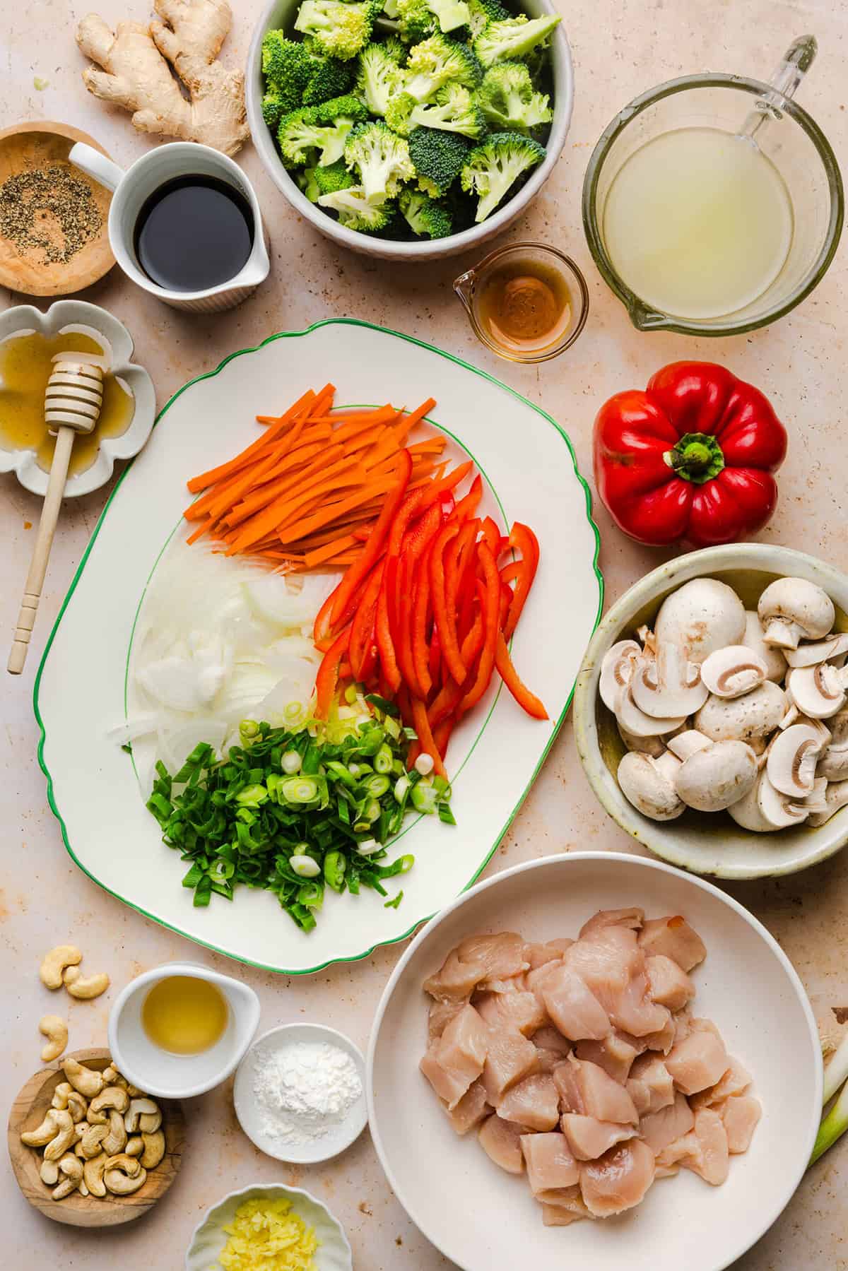 Fresh ingredients for teriyaki chicken stir fry including chicken breast, broccoli, carrots and bell peppers