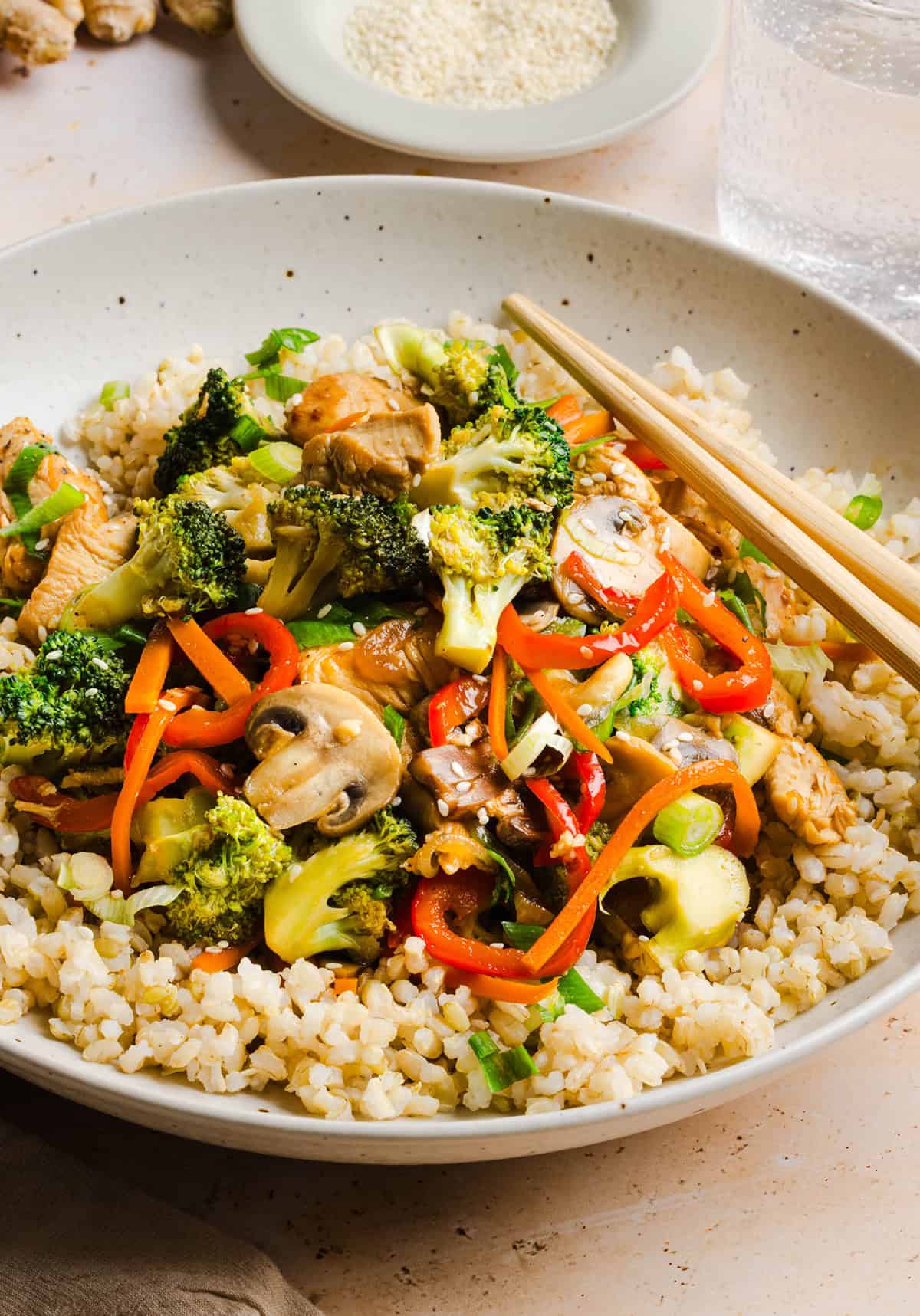 Teriyaki chicken with vegetables served over fluffy white rice and topped with sesame seeds
