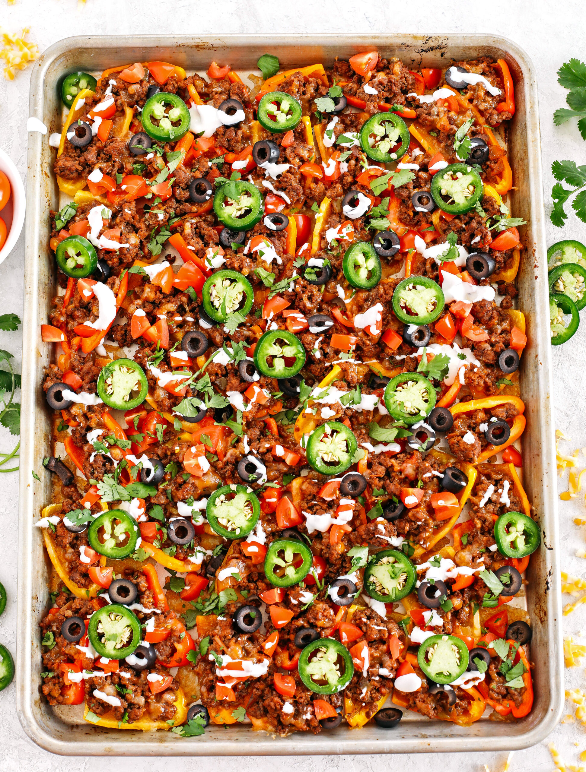 These Sheet Pan Loaded Bell Pepper Nachos are packed with all your favorite flavors and fun toppings making them the perfect low carb appetizer to enjoy on game day!  