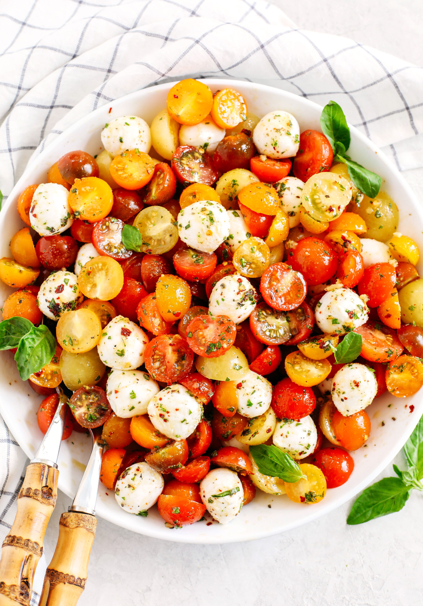 This Summer Caprese Salad is loaded with juicy tomatoes and creamy balls of mozzarella cheese all marinated in a delicious combination of olive oil, balsamic vinegar, garlic and fresh herbs!
