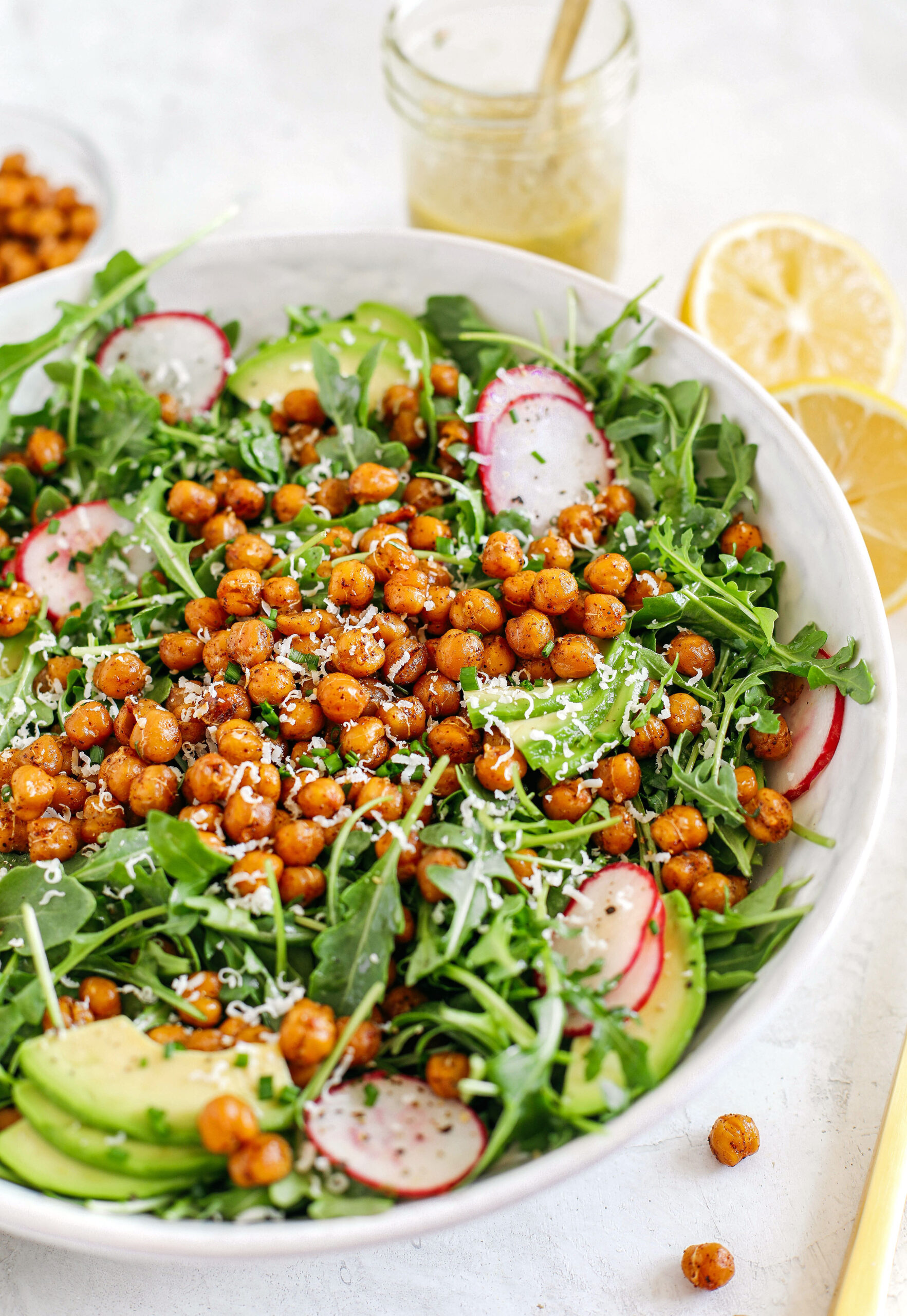 The most delicious Arugula Salad with Honey Roasted Chickpeas that are sweet, savory and perfectly crunchy!  Top with fresh veggies, avocado slices and my lemon dijon herb dressing!