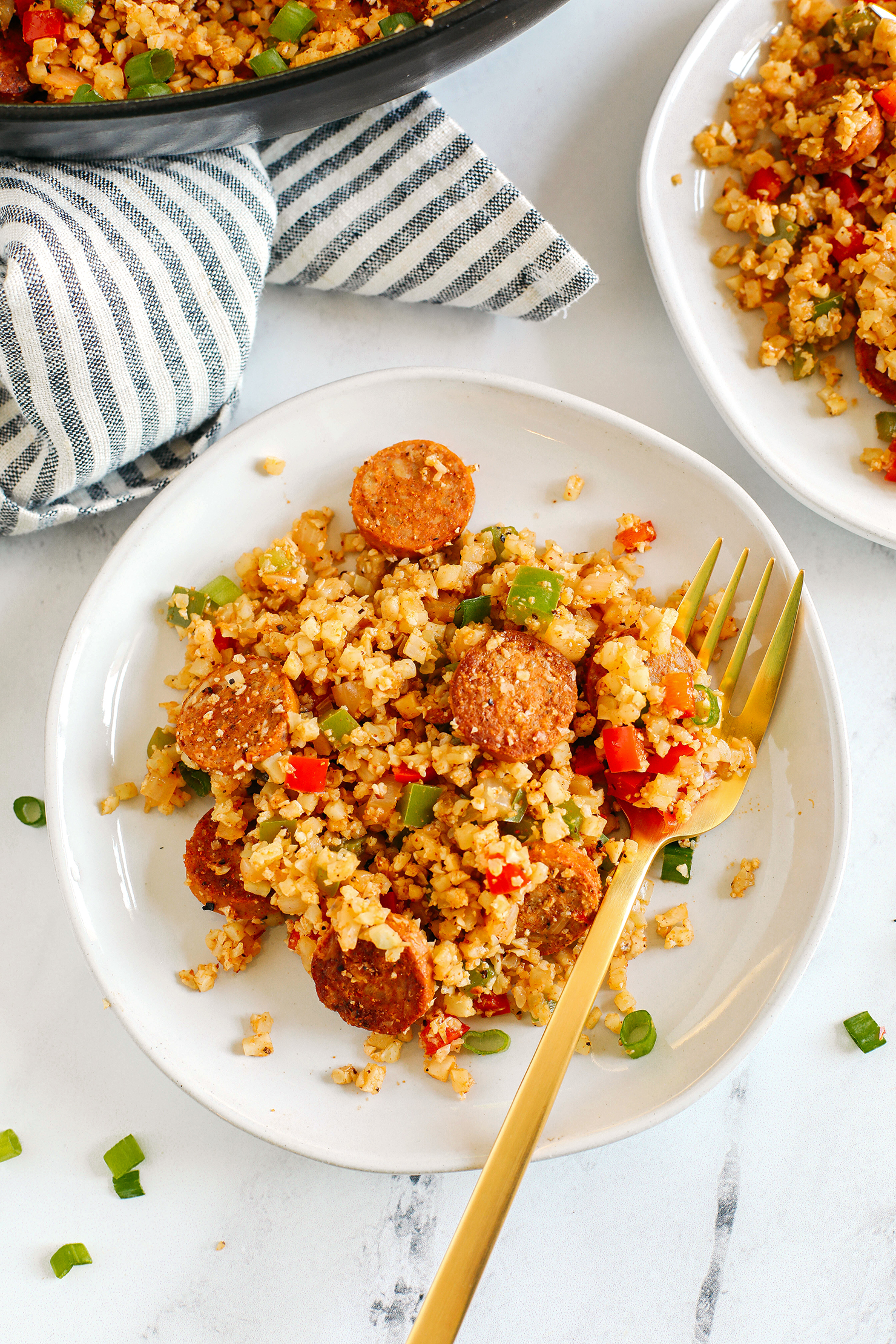 This Cajun Sausage and Cauliflower Rice Skillet is loaded with peppers, onions, andouille chicken sausage and tender riced cauliflower seasoned to perfection with our homemade Cajun seasoning!  The perfect low carb dinner for your family!