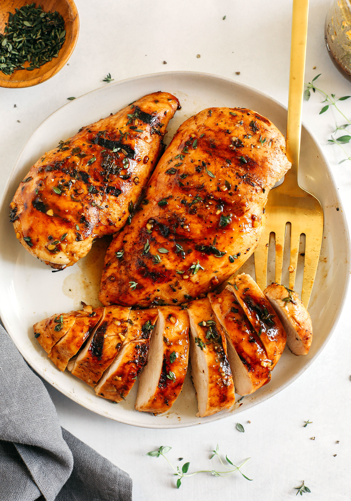 Moist and juicy chicken breasts marinated in a rich maple balsamic herb glaze, seasoned with fresh herbs, and grilled to perfection for a healthy weeknight meal!