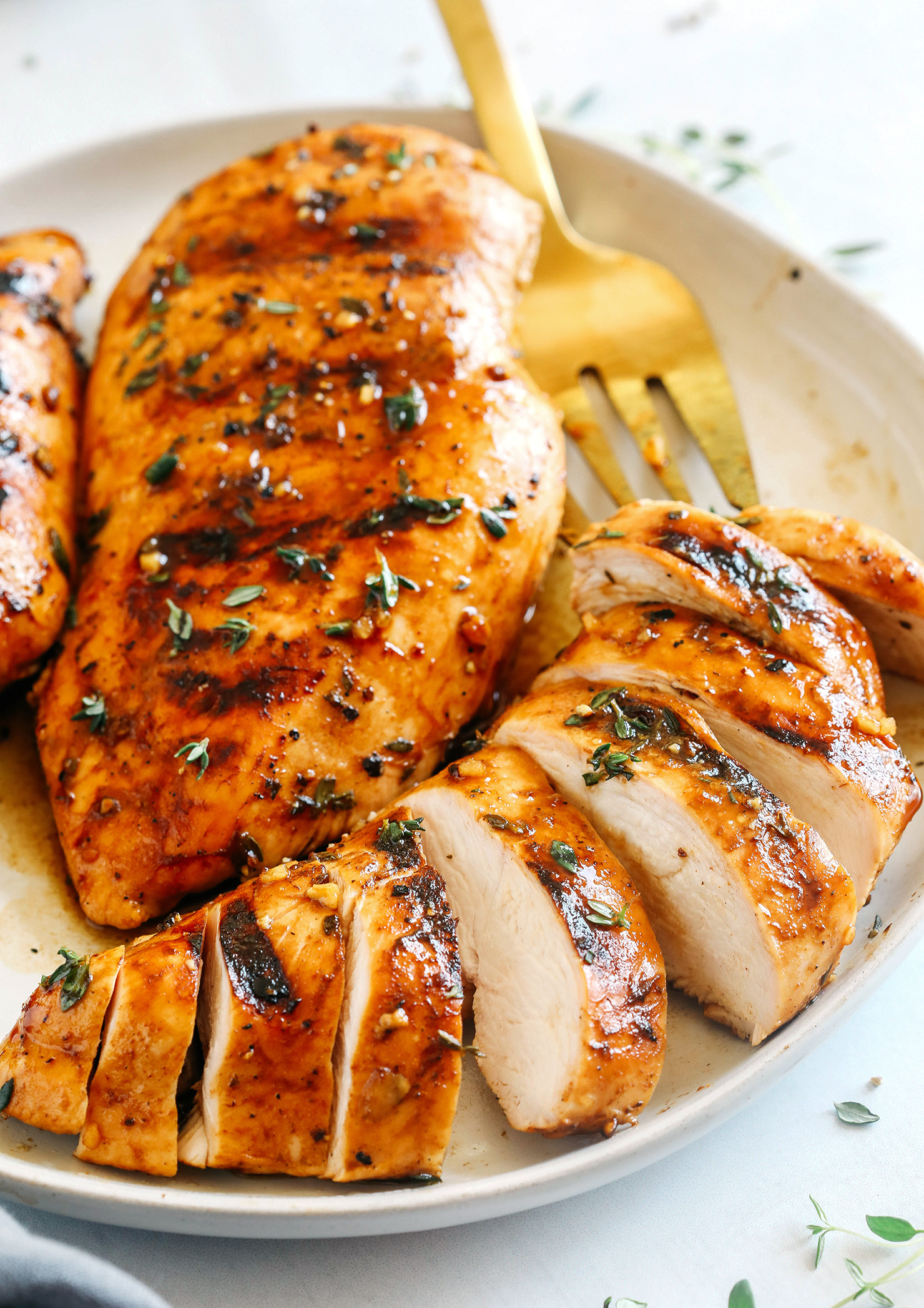 Moist and juicy chicken breasts marinated in a rich maple balsamic herb glaze, seasoned with fresh herbs, and grilled to perfection for a healthy weeknight meal!
