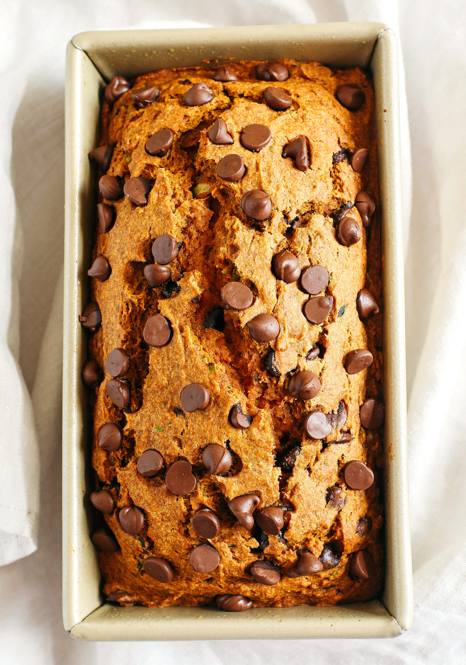 Healthy Pumpkin Zucchini Bread that is moist, fluffy and made healthier with whole wheat flour, Greek yogurt, shredded zucchini and zero butter or refined sugar.  Loaded with warm flavors and studded with chunks of chocolate in every bite!