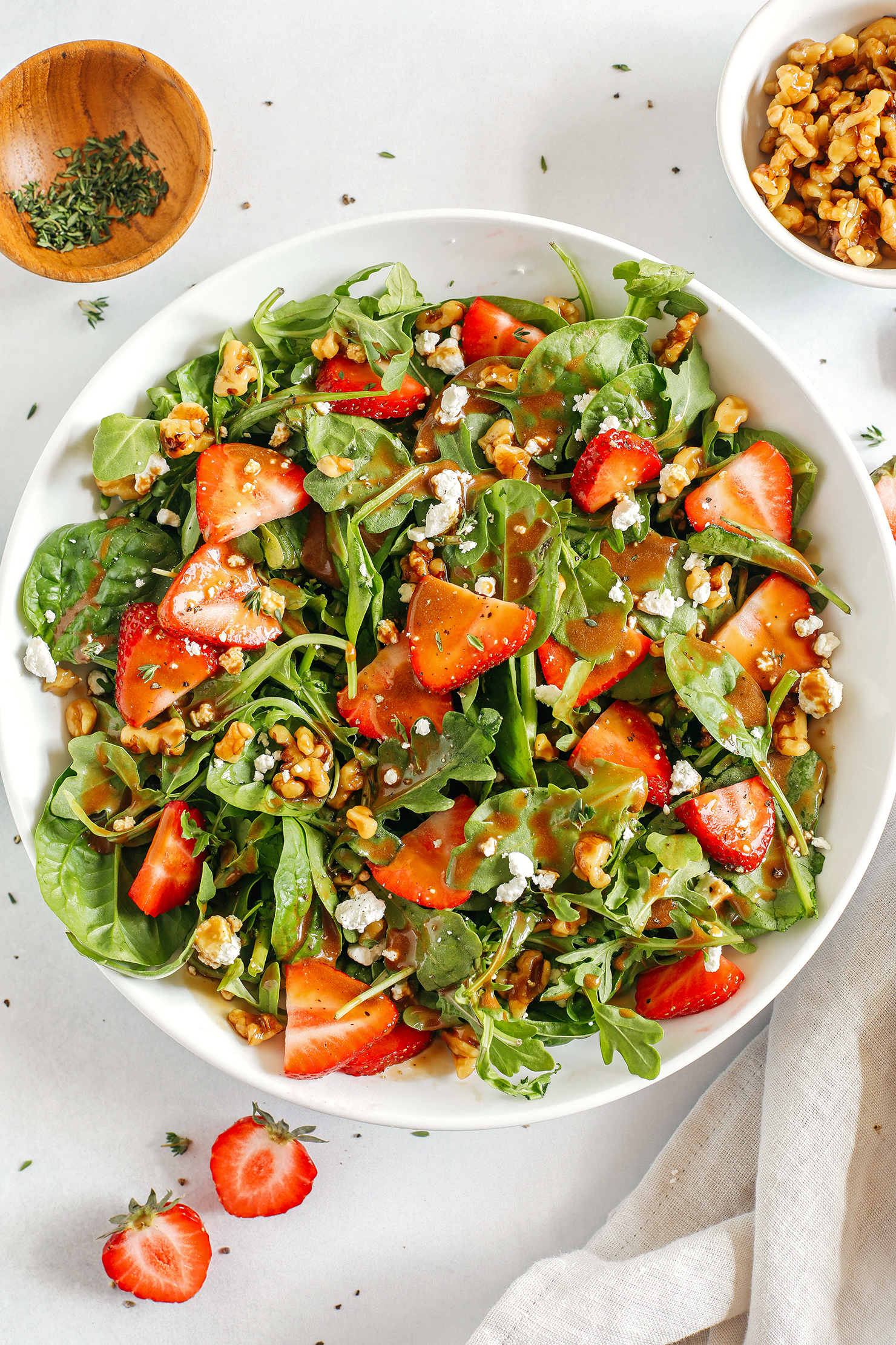 My favorite Strawberry Salad made with leafy greens, fresh strawberries, candied walnuts, and creamy goat cheese all tossed with a rich and tangy maple balsamic dressing!