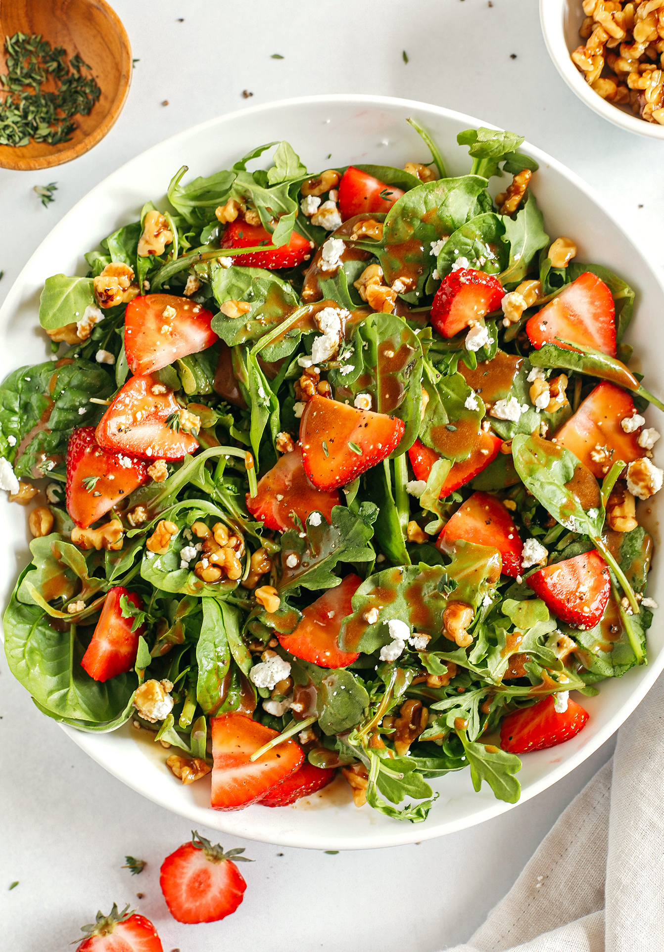 My favorite Strawberry Salad made with leafy greens, fresh strawberries, candied walnuts, and creamy goat cheese all tossed with a rich and tangy maple balsamic dressing!