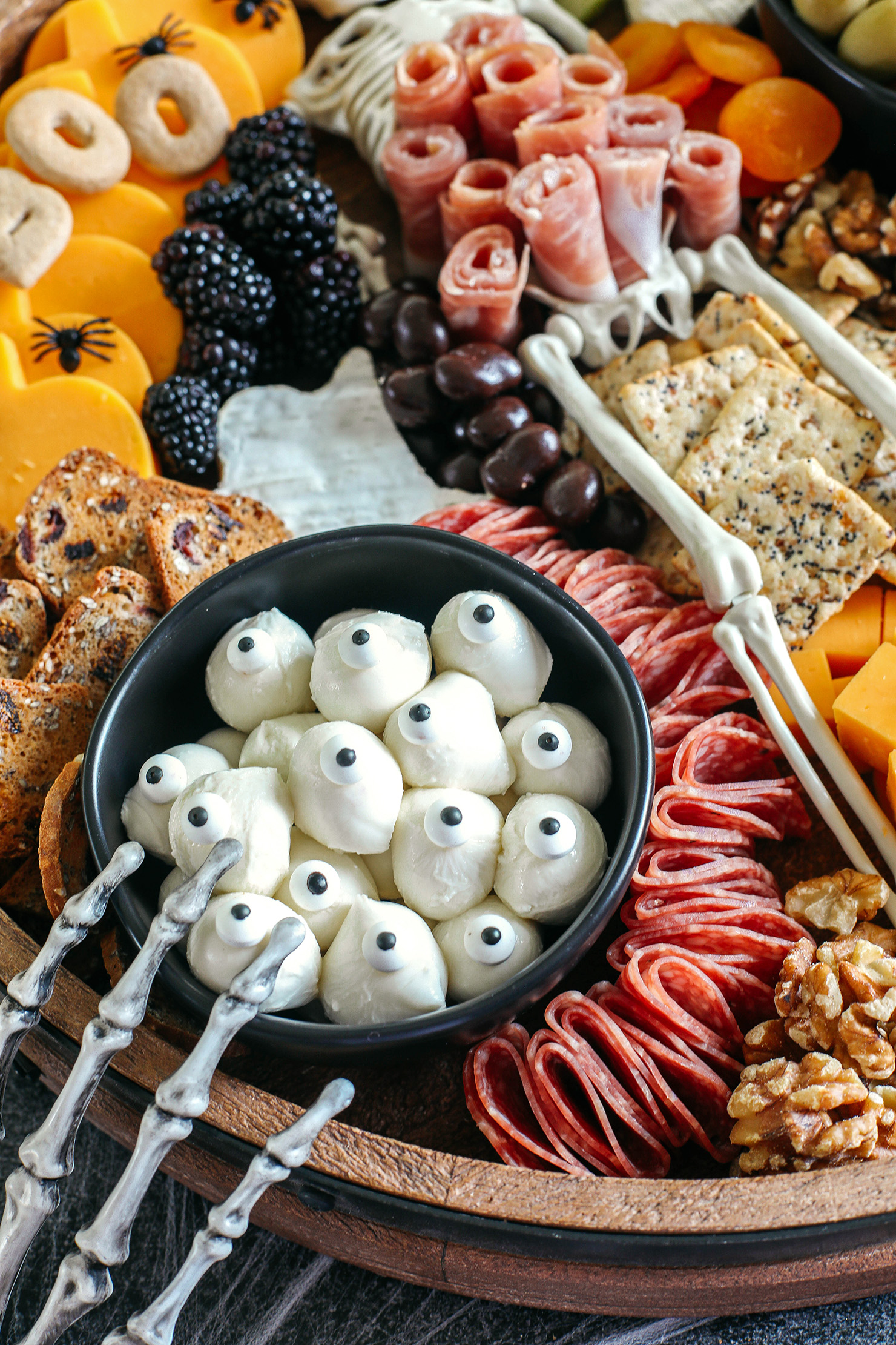 Build the spookiest Halloween Charcuterie Board perfect for your next party!  Filled with an assortment of your favorite cheeses, meats, crackers, fresh fruits, nuts and other fun ghoulish treats!