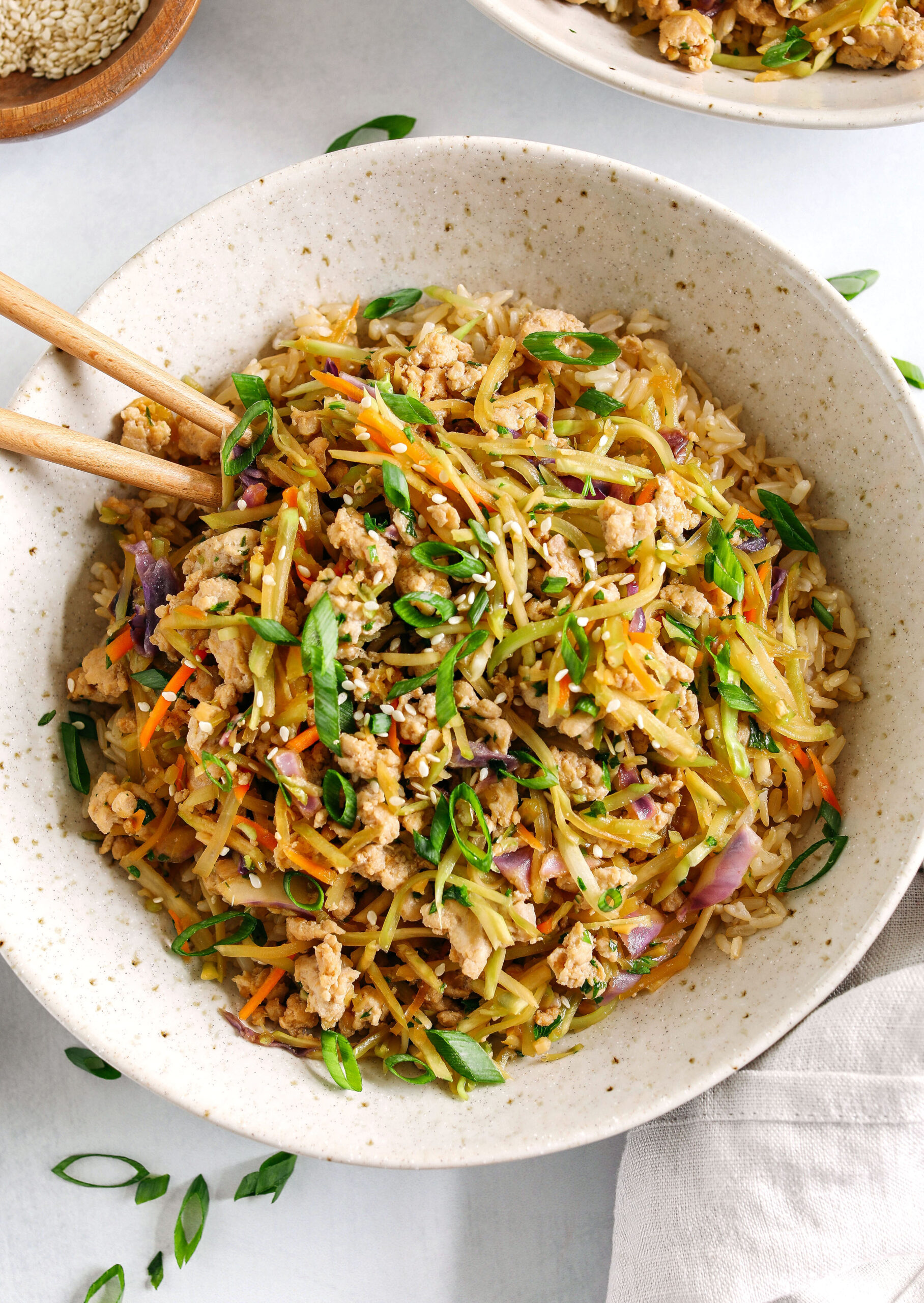 Easy and flavorful Chicken Egg Roll in a Bowl that comes together in under 20 minutes packed with so much flavor!  Perfect healthy weeknight dinner served over rice and garnished with green onions and sesame seeds.