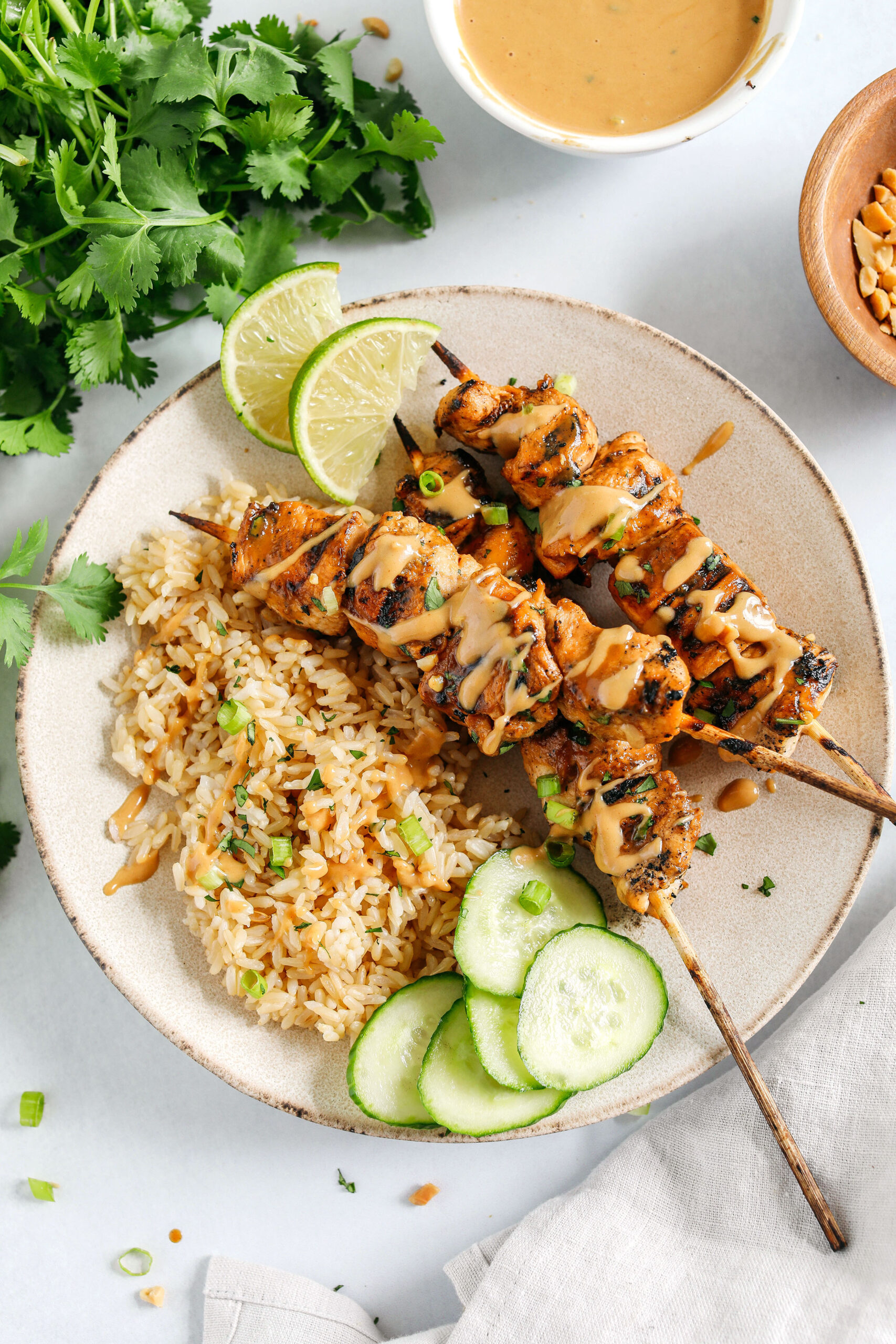 Tender and juicy Chicken Satay marinated in the most delicious peanut ginger sauce and grilled to perfection for the perfect easy weeknight dinner!  Serve over rice or salad and drizzled with my homemade peanut sauce.