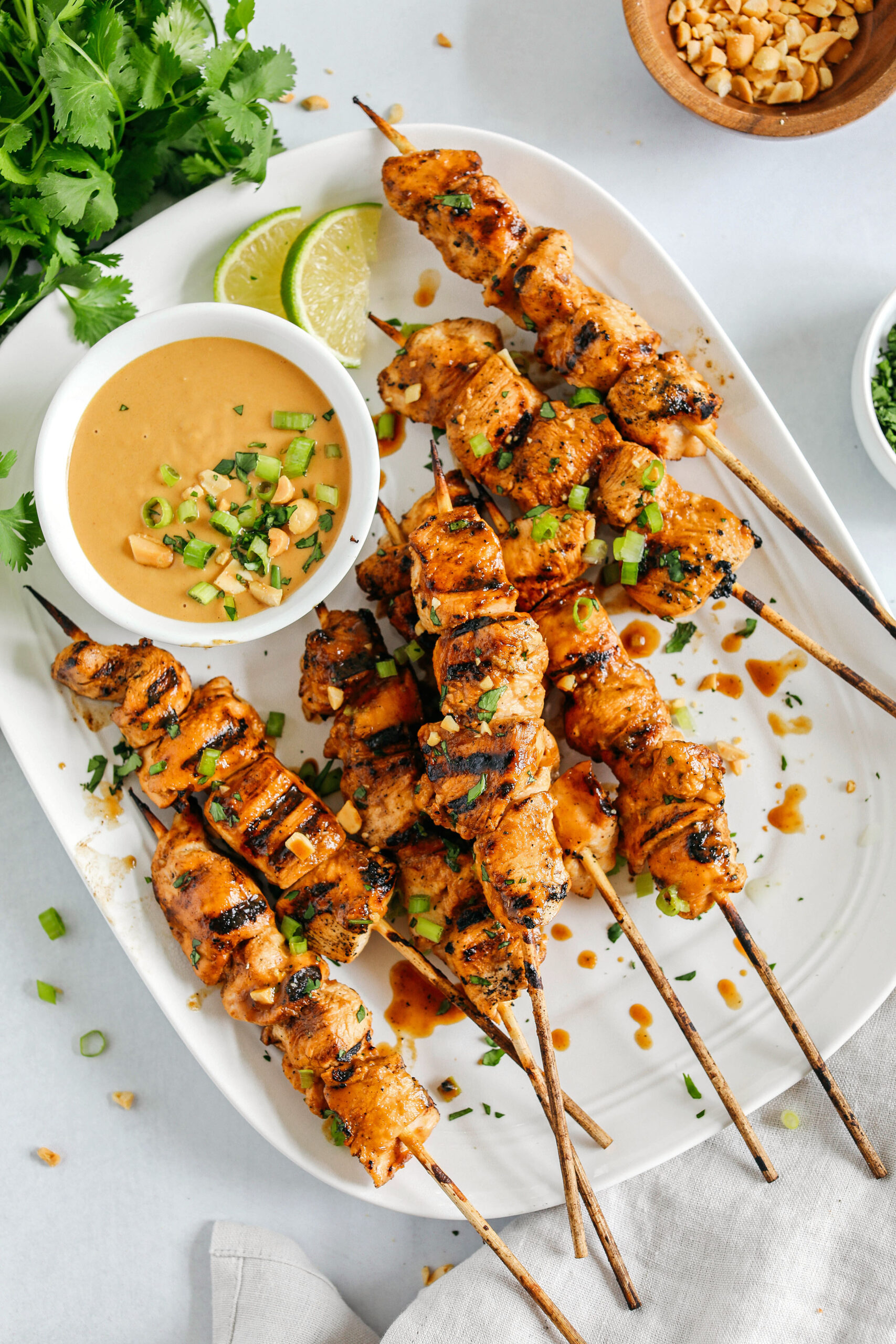 Tender and juicy Chicken Satay marinated in the most delicious peanut ginger sauce and grilled to perfection for the perfect easy weeknight dinner!  Serve over rice or salad and drizzled with my homemade peanut sauce.