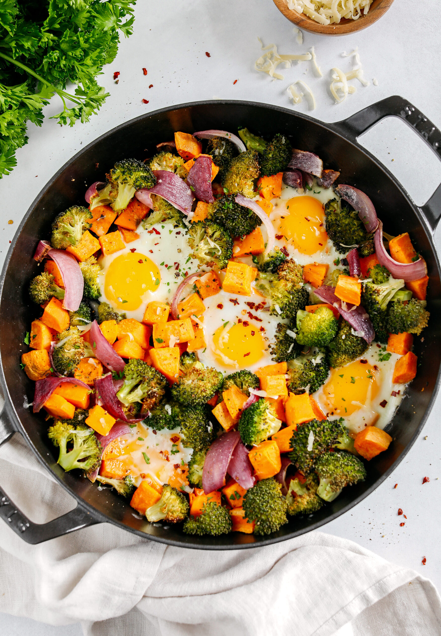 Roasted Veggie Breakfast Skillet made all in one pan with a hearty combination of sweet potatoes, broccoli and red onion topped with baked eggs and seasoned to perfection for a healthy delicious breakfast or dinner!