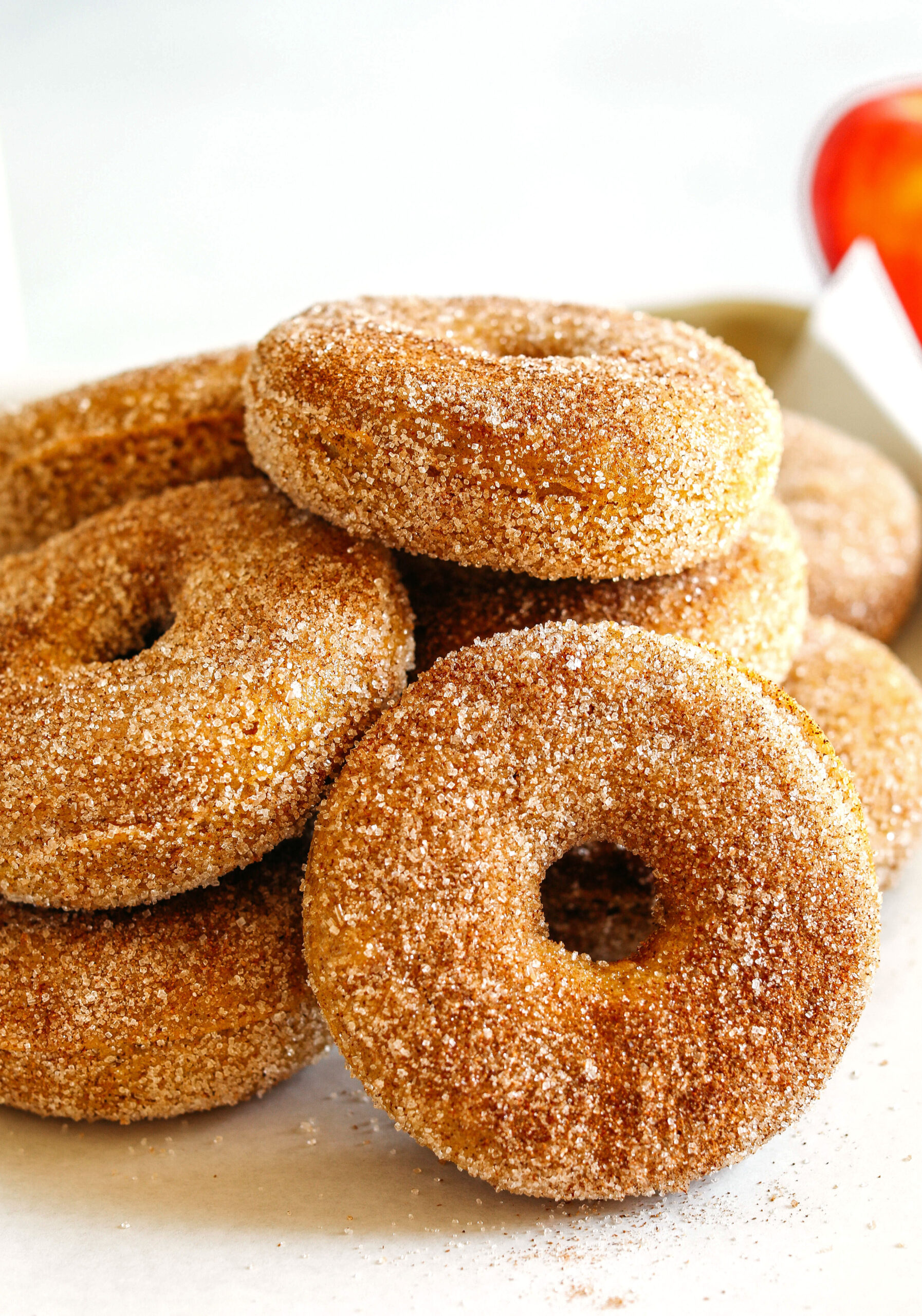 Soft Baked Apple Cider Donuts made healthier with whole wheat flour, applesauce and Greek yogurt for the perfect fall treat that comes together in just 20 minutes!  Loaded with warm spices and coated with cinnamon and sugar!