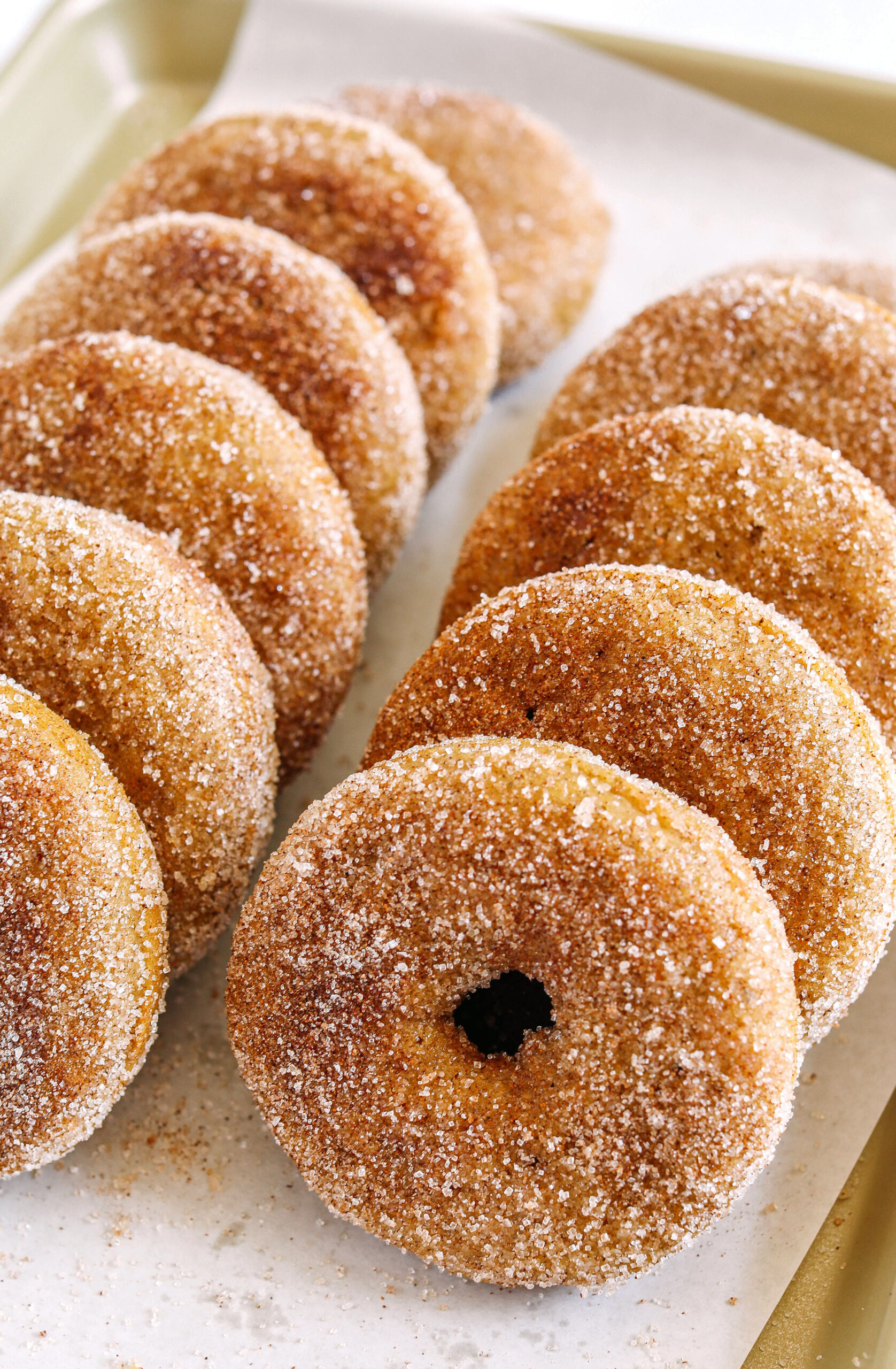 Soft Baked Apple Cider Donuts made healthier with whole wheat flour, applesauce and Greek yogurt for the perfect fall treat that comes together in just 20 minutes!  Loaded with warm spices and coated with cinnamon and sugar!