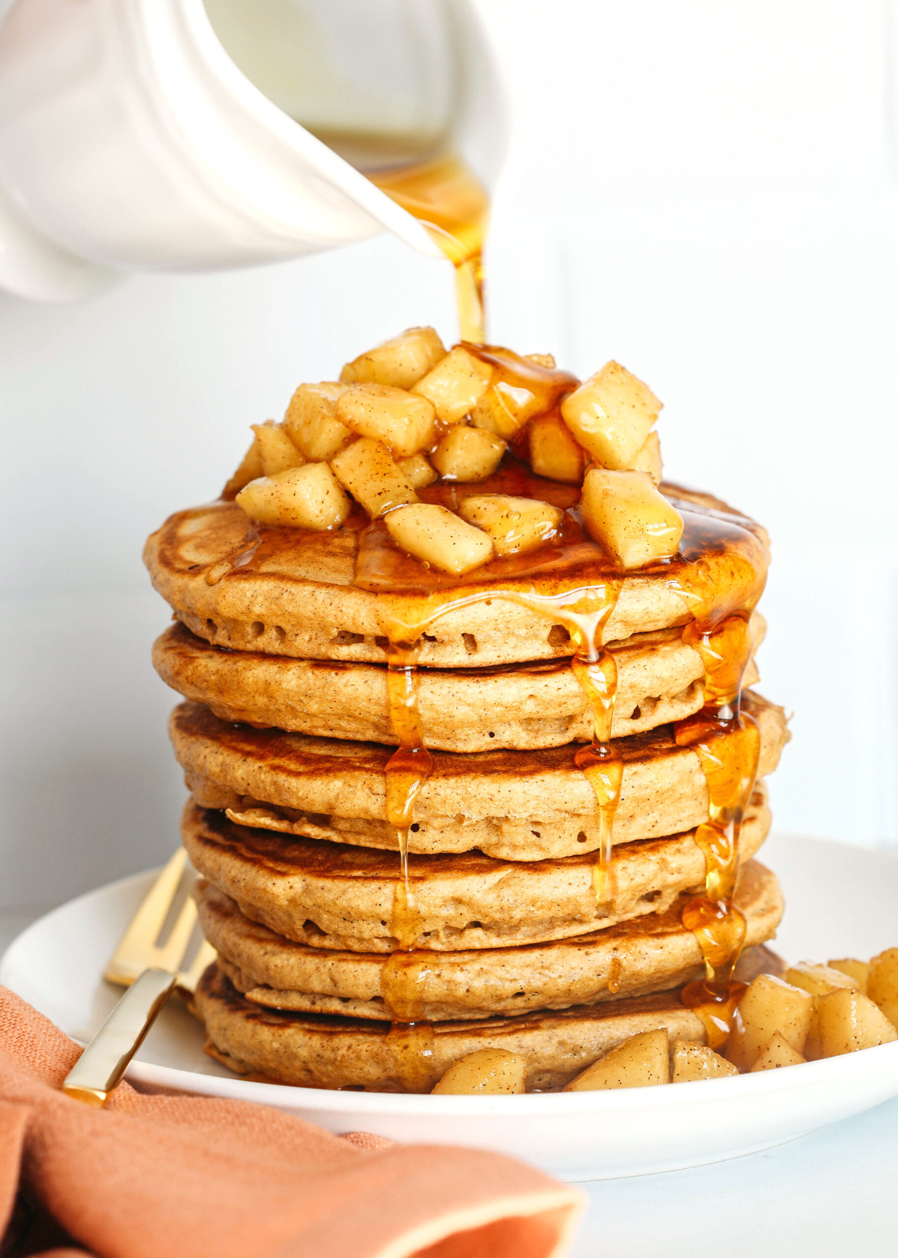 Light and fluffy Apple Cinnamon Pancakes made healthier with whole wheat flour, applesauce in place of oil and zero butter or refined sugar!  Topped with warm spiced apples and drizzled with maple syrup!