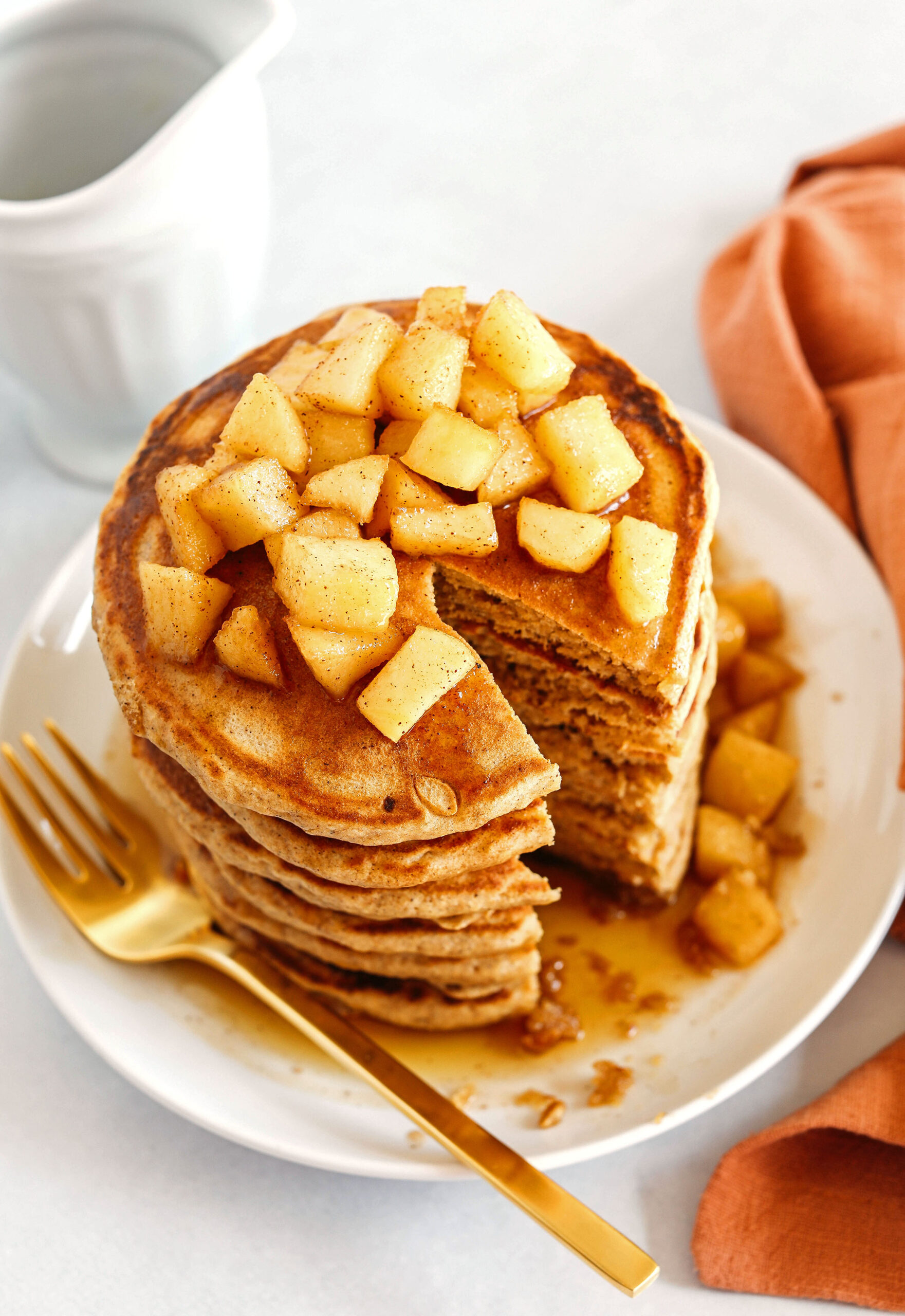 Light and fluffy Apple Cinnamon Pancakes made healthier with whole wheat flour, applesauce in place of oil and zero butter or refined sugar!  Topped with warm spiced apples and drizzled with maple syrup!