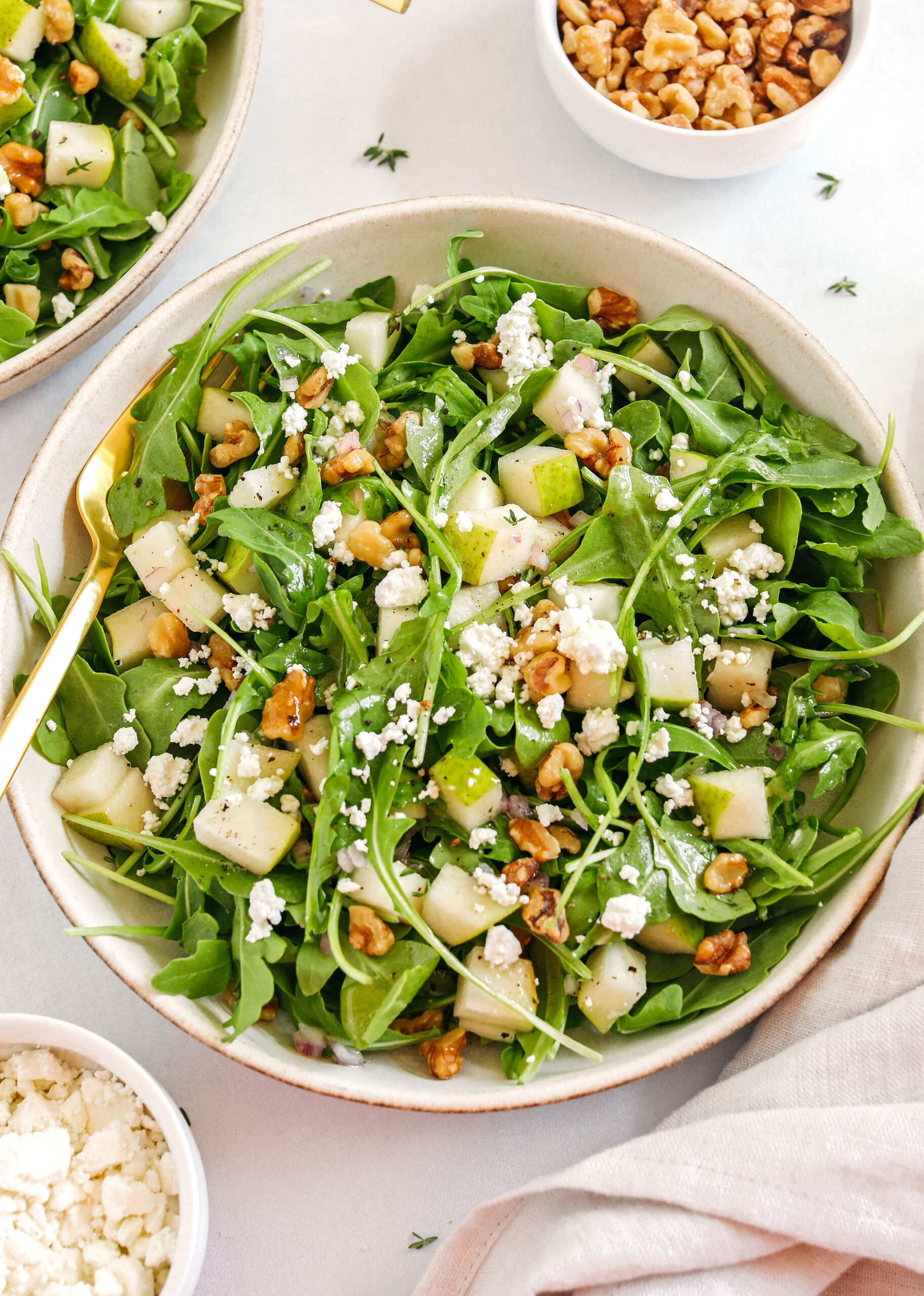 This simple Pear and Arugula Salad is made with fresh arugula, chopped pears, creamy goat cheese and crunchy pecans all tossed with a bright and lemony honey vinaigrette!  The perfect fall salad that is super easy to throw together!