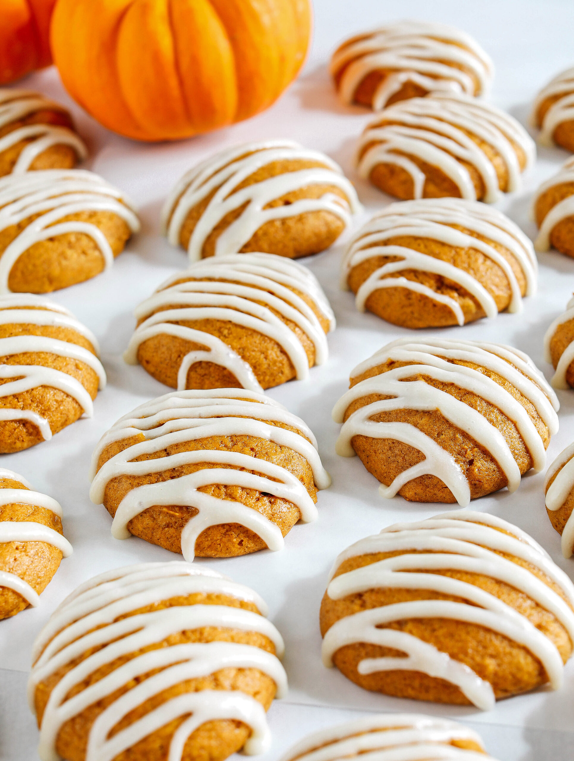 Pillowy soft Iced Pumpkin Cookies made healthier with whole wheat flour and zero butter or refined sugar all drizzled with a delicious maple cream cheese icing!  These cake-like pumpkin cookies make the perfect fall treat to enjoy this season.