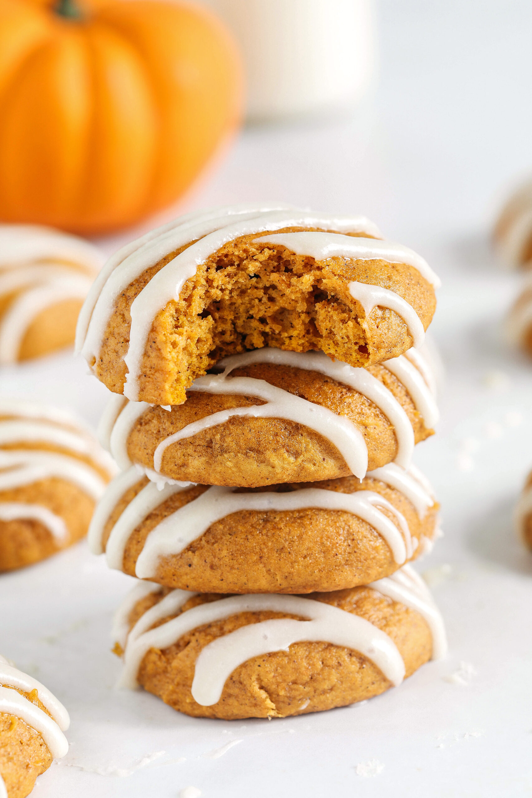 Pillowy soft Iced Pumpkin Cookies made healthier with whole wheat flour and zero butter or refined sugar all drizzled with a delicious maple cream cheese icing!  These cake-like pumpkin cookies make the perfect fall treat to enjoy this season.
