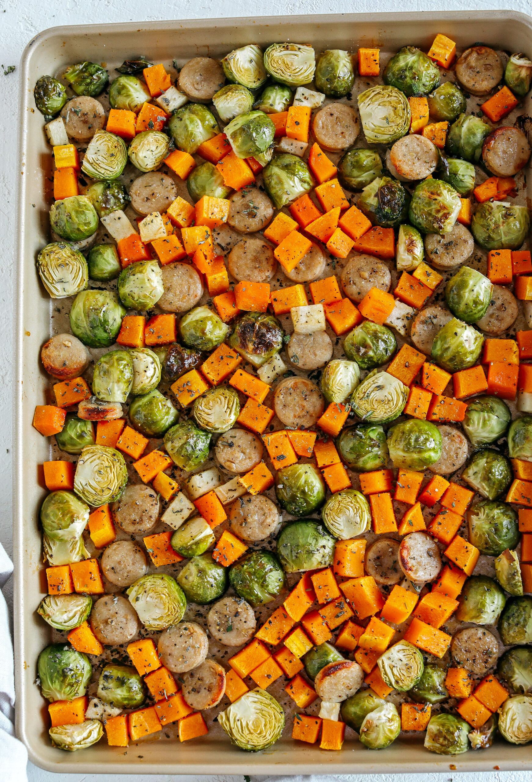Harvest Sheet Pan Sausage and Veggies loaded with flavorful chicken sausage, butternut squash, brussels sprouts, and apples for a quick and easy dinner made in just 30 minutes!  Roasted in a maple mustard glaze and fresh herbs for the perfect fall meal!  