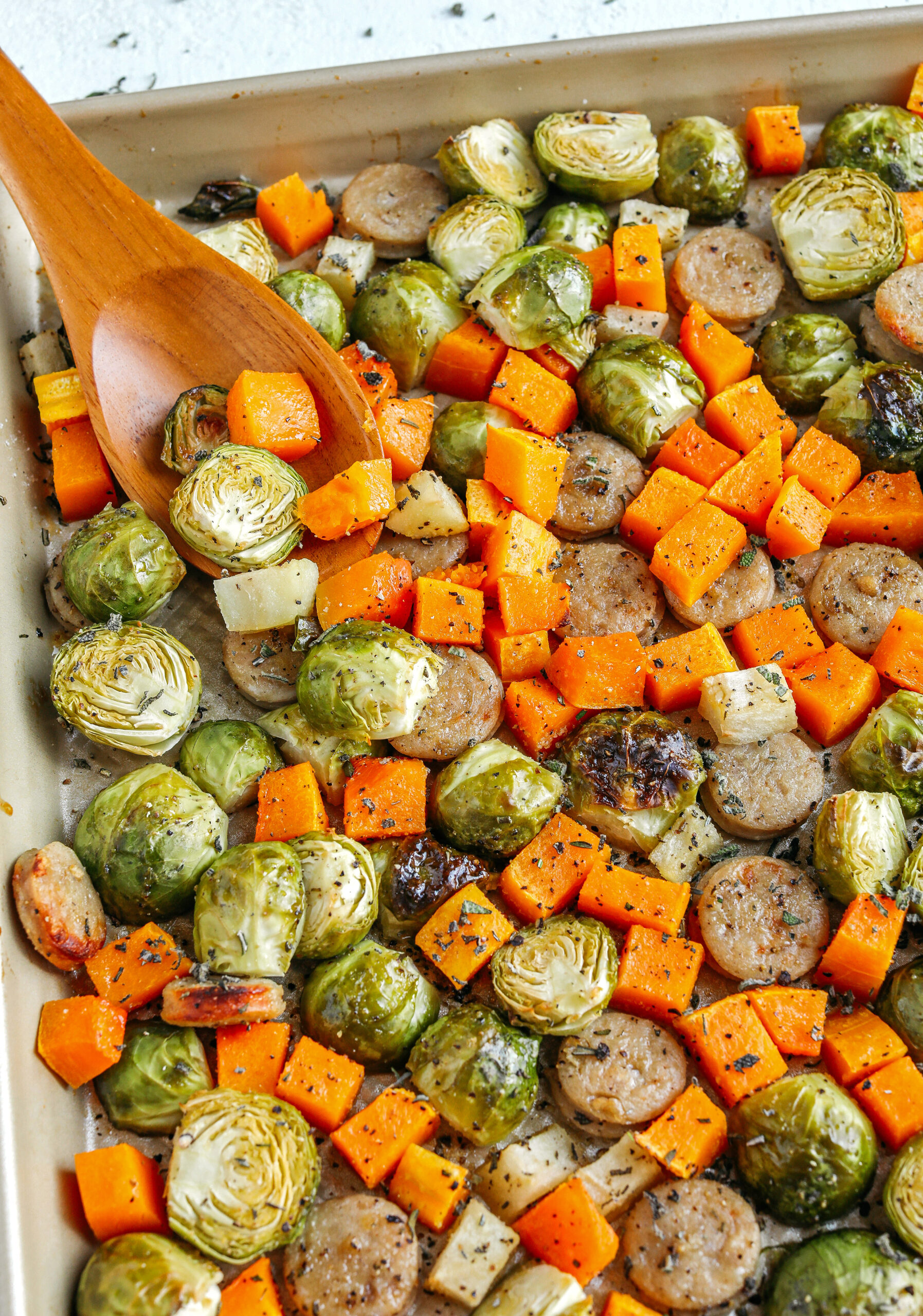 Harvest Sheet Pan Sausage and Veggies loaded with flavorful chicken sausage, butternut squash, brussels sprouts, and apples for a quick and easy dinner made in just 30 minutes!  Roasted in a maple mustard glaze and fresh herbs for the perfect fall meal!  