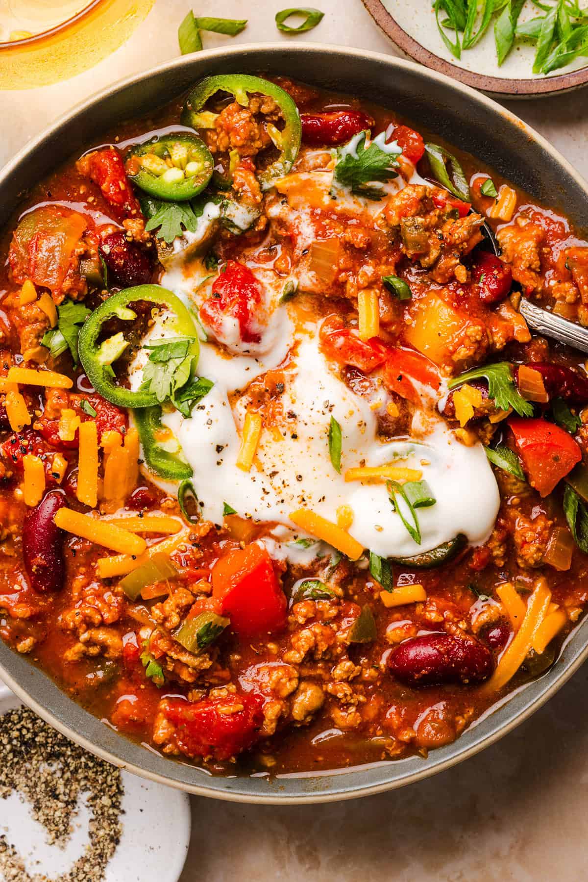 Healthy turkey chili topped with sour cream, cilantro, and green onions.