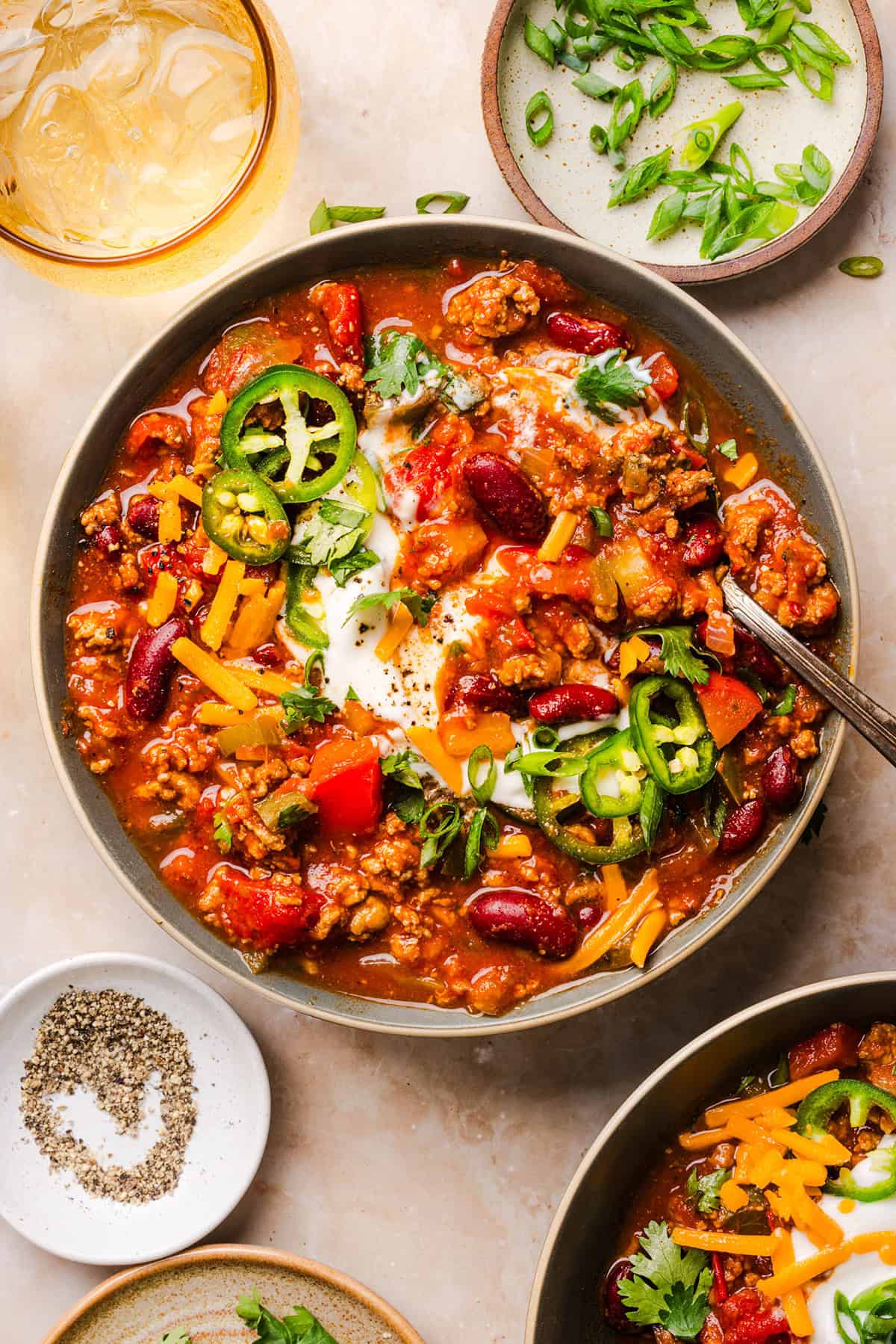 Healthy turkey chili topped with sour cream, cilantro, and green onions.