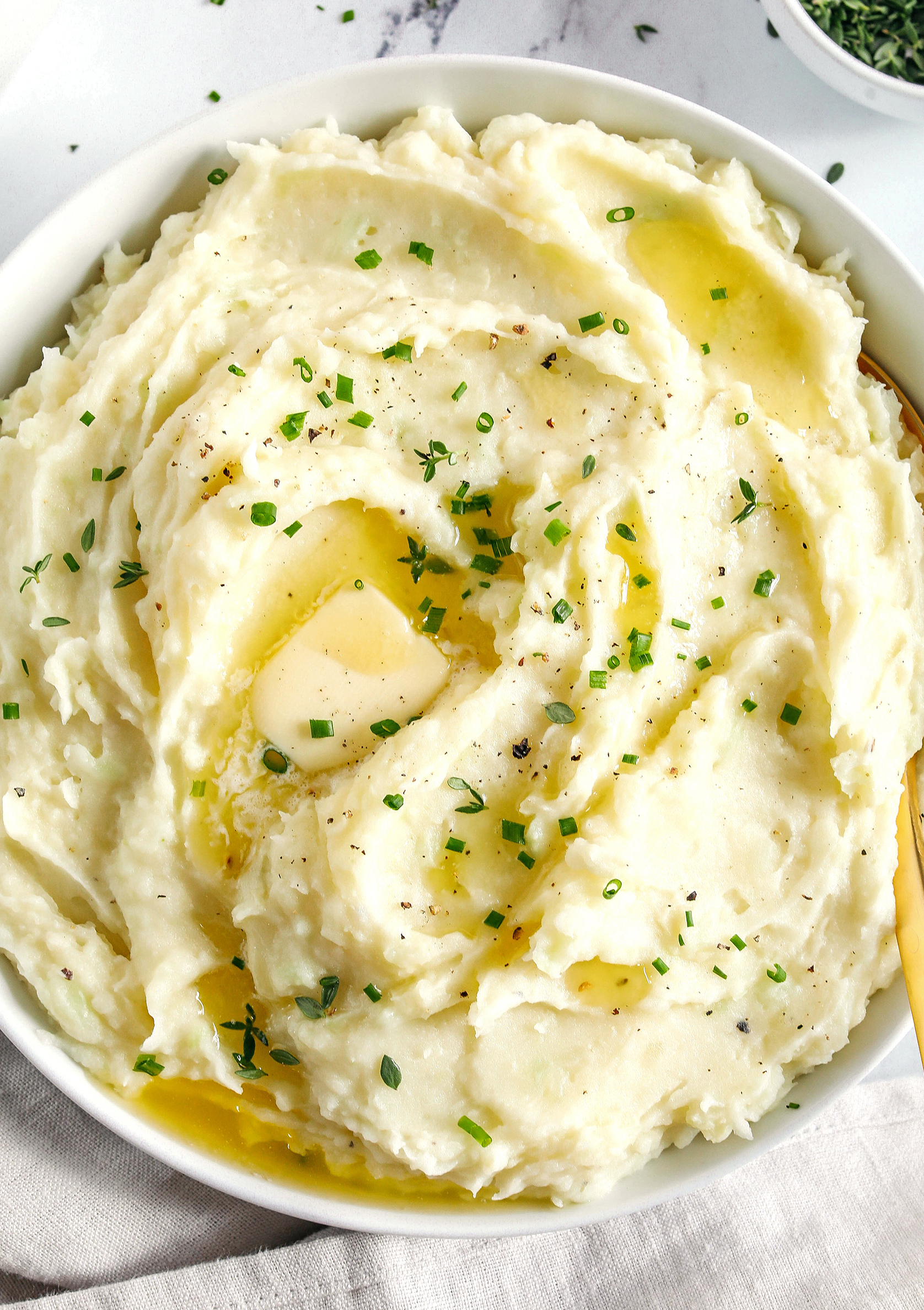 These Healthy Mashed Potatoes are creamy, absolutely delicious and made lighter with Greek yogurt, almond milk and a whole head of cauliflower!  The perfect side dish for your holiday table or weeknight dinner.