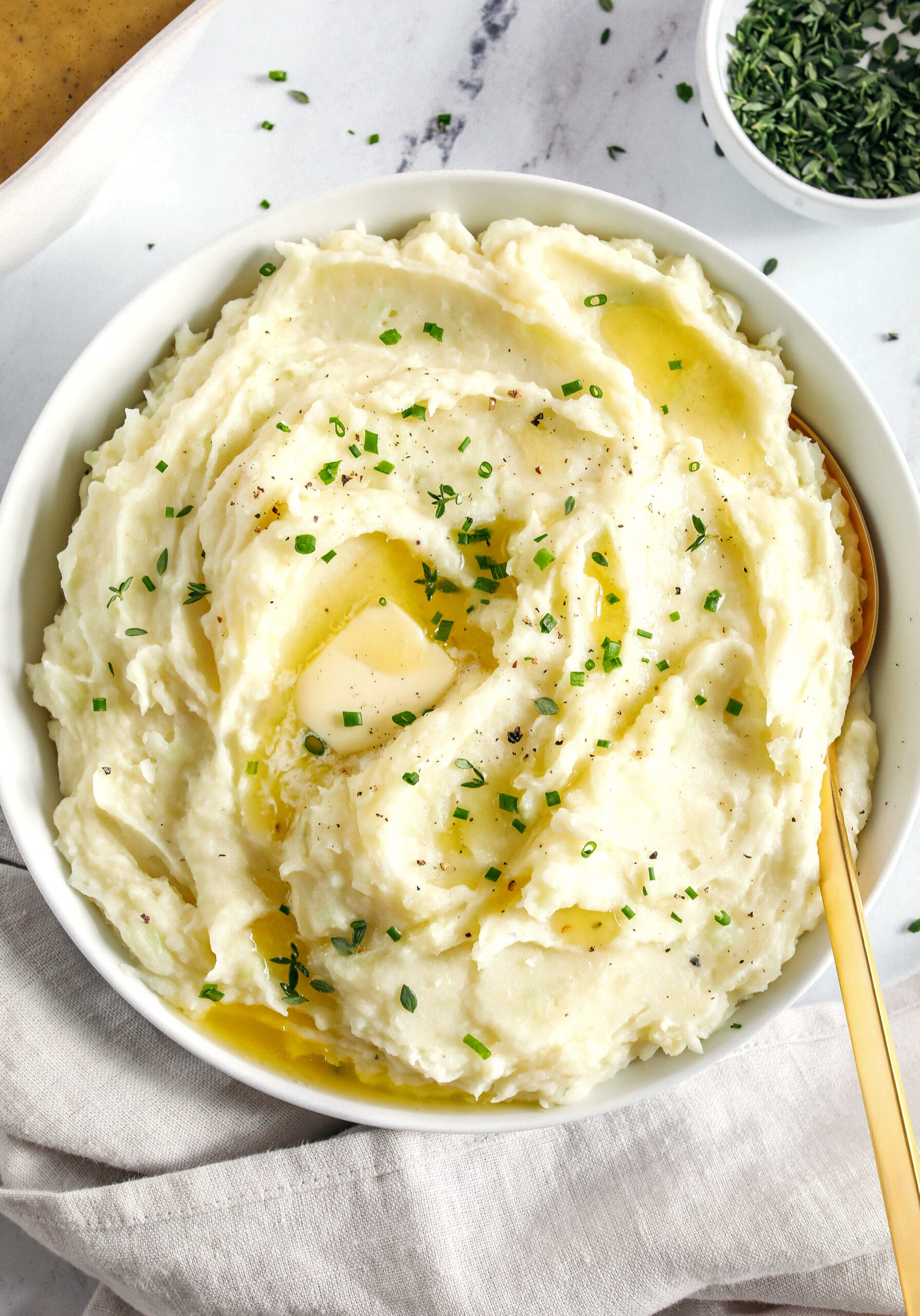 These Healthy Mashed Potatoes are creamy, absolutely delicious and made lighter with Greek yogurt, almond milk and a whole head of cauliflower!  The perfect side dish for your holiday table or weeknight dinner.