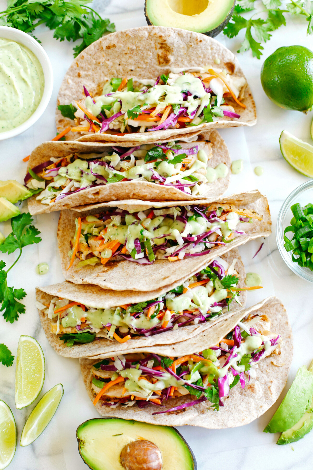 Easy and delicious Cilantro Lime Chicken Tacos topped with tangy coleslaw and homemade avocado crema make the perfect EASY summer recipe!  Full of fresh flavors and healthy ingredients!