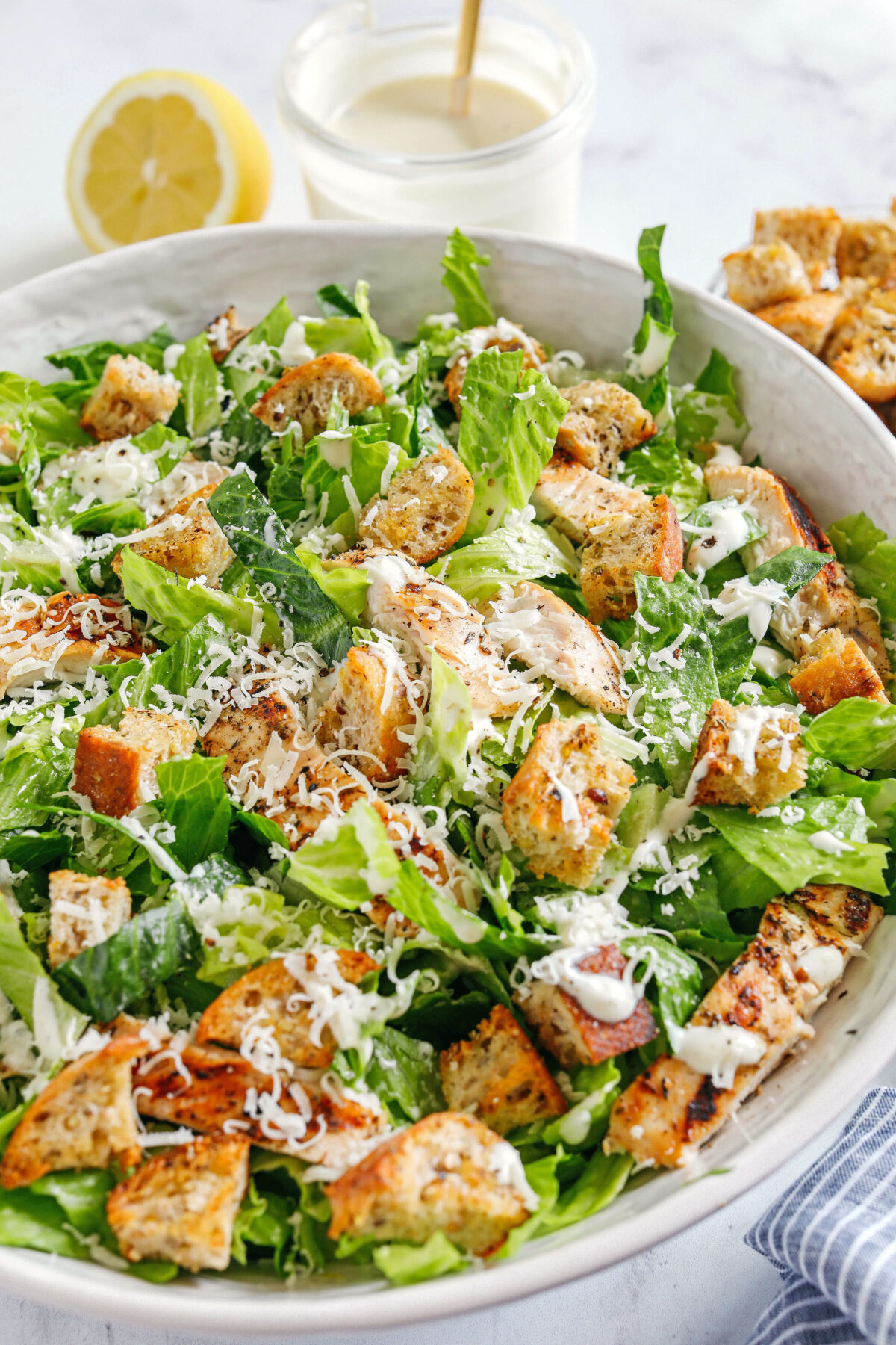 The BEST Healthy Chicken Caesar Salad made with grilled lemon chicken, garlicky homemade croutons, fresh parmesan cheese and tossed with a lightened up Greek yogurt dressing!