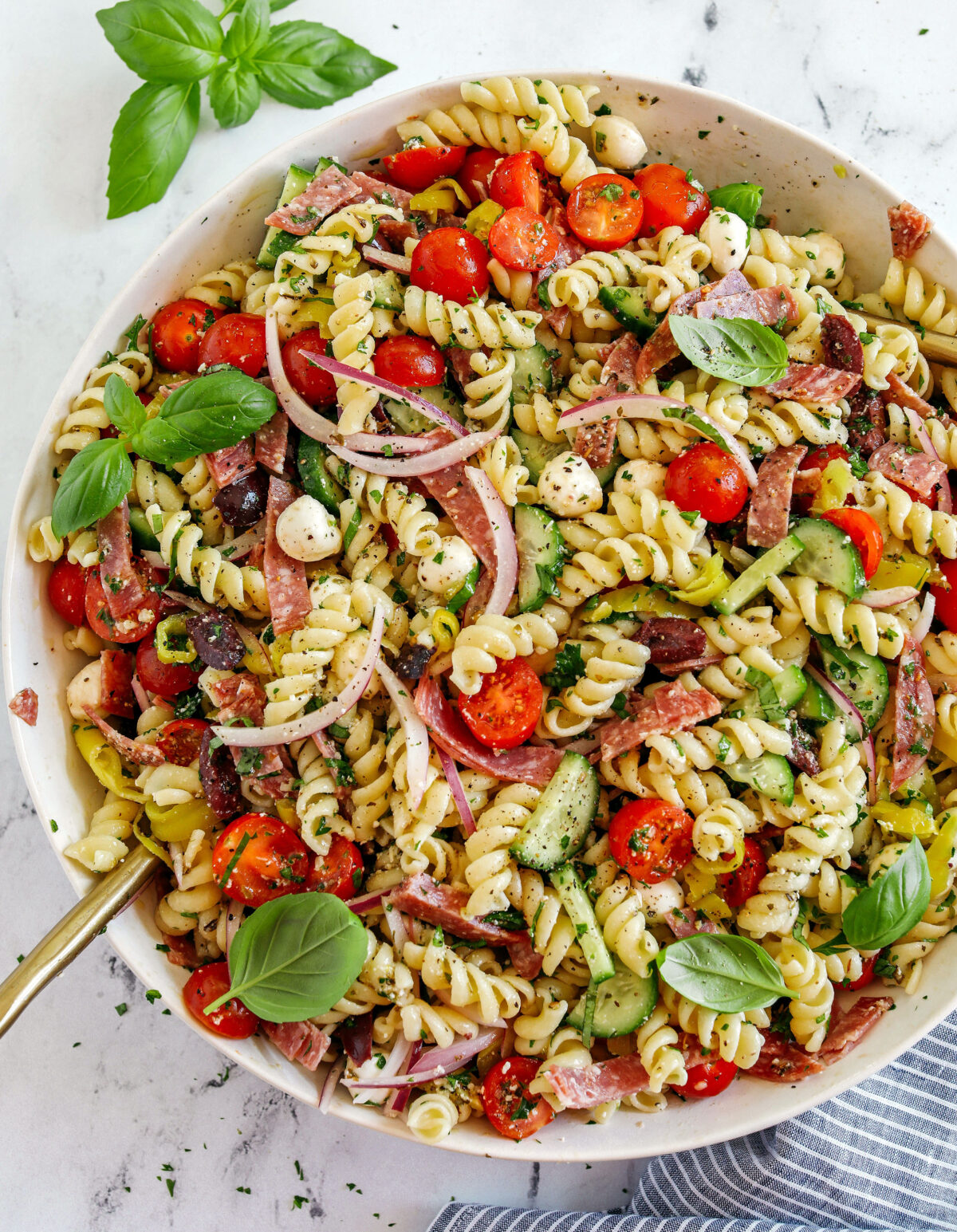 This EASY Italian Pasta Salad is loaded with juicy tomatoes, cucumbers, fresh mozzarella, spicy salami, pepperoncini, red onion and olives all tossed together with a zesty homemade Italian dressing!