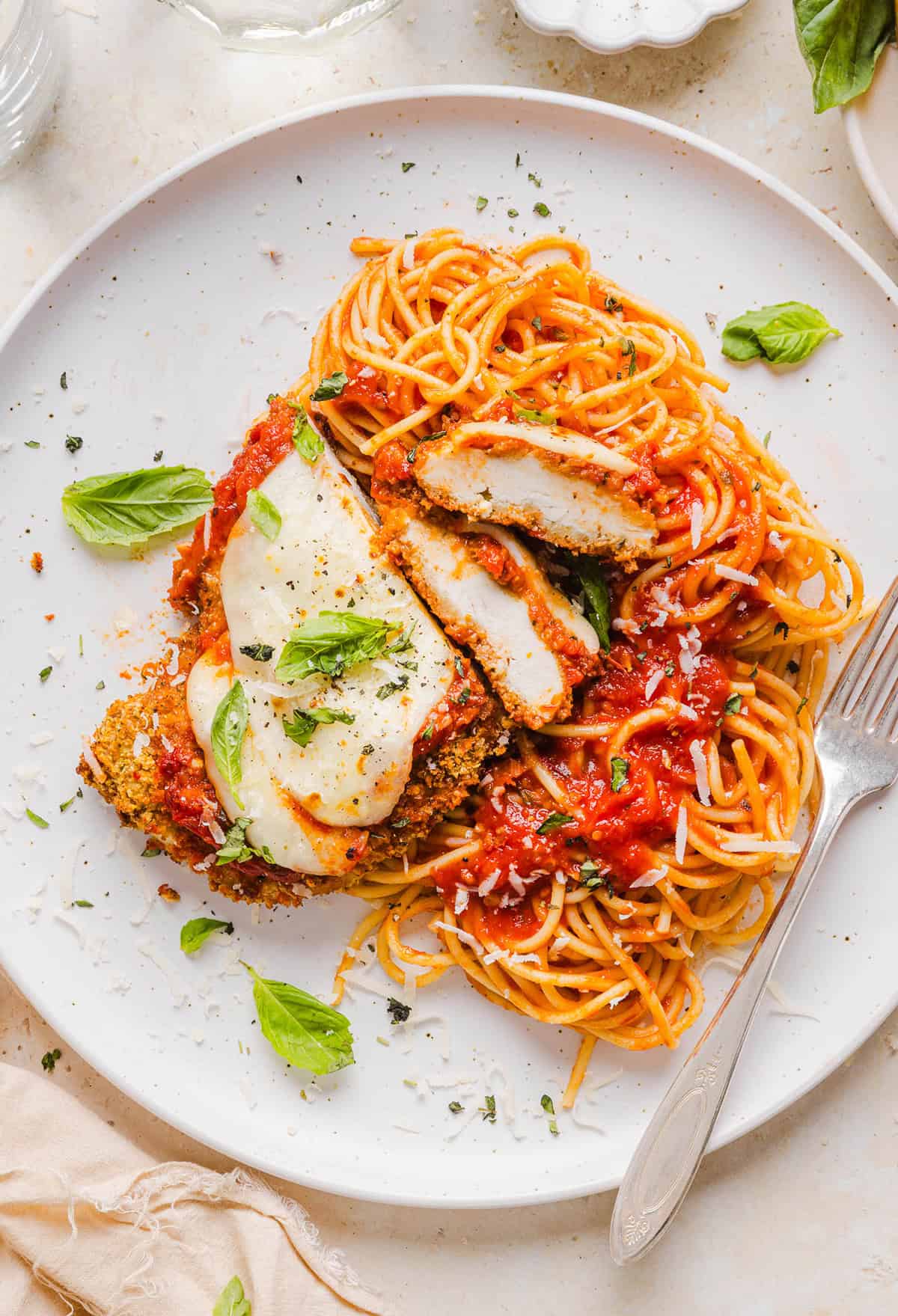 Easy Baked Chicken Parmesan made with tender juicy chicken, rich marinara sauce and melty cheese with a crisp coating that tastes delicious! This chicken is baked, not fried, and easily comes together in under 30 minutes!