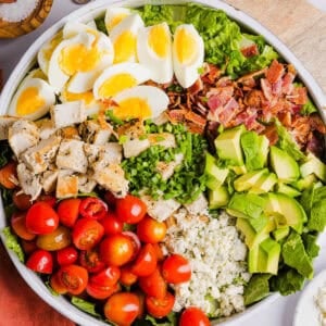Protein-packed Chicken Cobb Salad loaded with tender chicken, crispy bacon, creamy avocado and tangy blue cheese all tossed in a delicious red wine vinaigrette! A fresh, hearty and satisfying salad that is perfect for lunch or a light dinner.